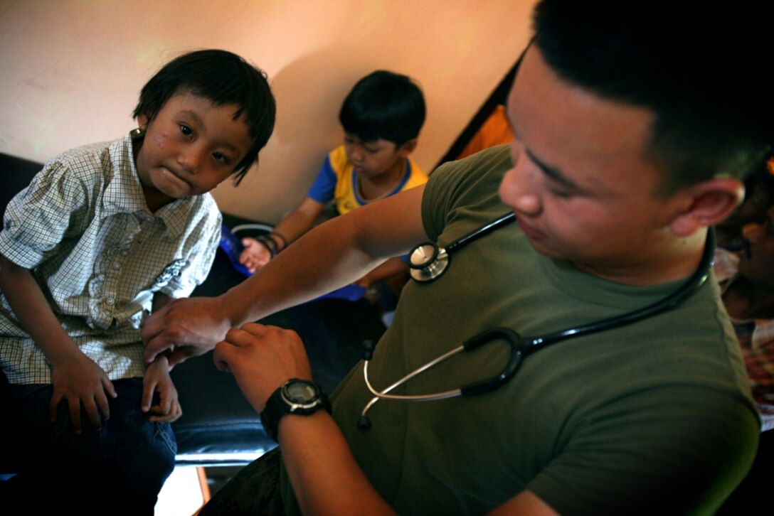 Petty Officer 2nd Class Kevin Keosibounheuang, a hospital corpsman with the 11th Marine Expeditionary Unit, checks the vital signs of a young patient at a clinic here Oct. 19. Medical personnel treated over 1000 people Oct. 19-21 as part of a medical assistance program. Members of the 11th MEU are in Indonesia for an exercise focused on medical and dental assistance, engineering projects and military interaction.