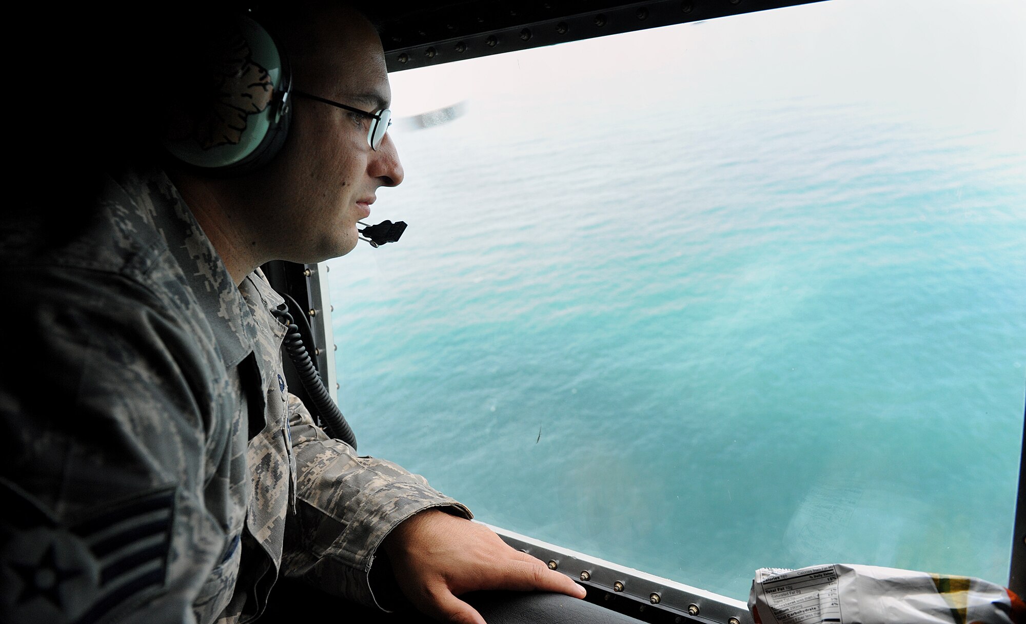 MOODY AIR FORCE BASE, Ga. -- Staff Sgt. Sean Clark, 723rd Aircraft Maintenance Squadron crew chief, scans the Atlantic Ocean here Oct. 17. Sergeant Clark was part of a personnel recovery team in search of a missing F-16 Fighting Falcon pilot from Shaw Air Force Base, S.C. (U.S. Air Force photo by Airman 1st Class Joshua Green)
