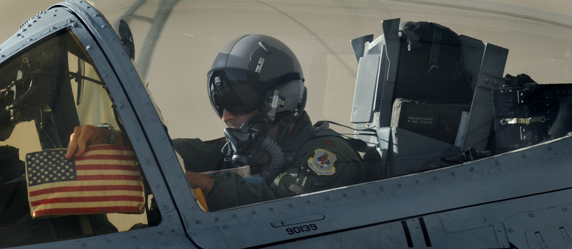 MOODY AIR FORCE BASE, Ga. – Maj. John Lesho, 76th Fighter Squadron A-10C pilot, displays an American flag in the cockpit of the A-10 he will fly to Red Flag at Nellis Air Force Base, Nev., here Oct. 17. (U.S. Air Force photo by Staff Sgt. Elizabeth Rissmiller)