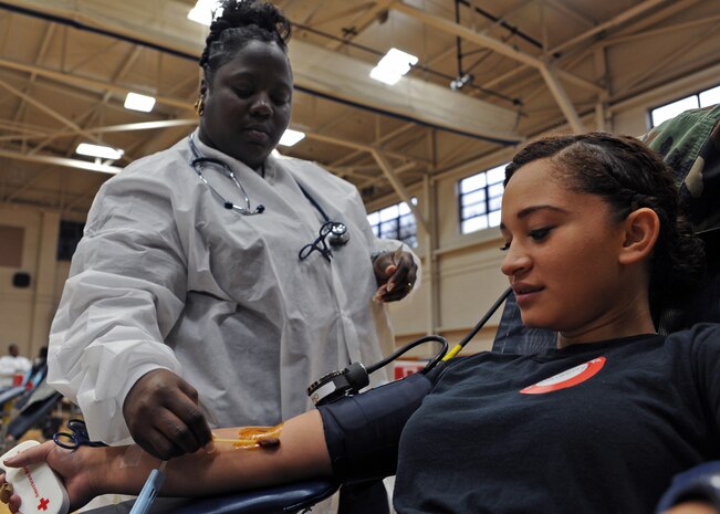 Airman 1st Class Daigerrys Leon prepares to give blood while Ashia Smalls sterilizes her forearm during a 437th Medical Group sponsored blood drive at the Fitness and Sports Center here Oct. 14. The Red Cross provided phlebotomists to take blood. For each Airman who donated, up to three lives can be saved. Airman Leon is a readiness journeyman with the 437th Civil Engineer Squadron and Ms. Smalls is a phlebotomist with the Red Cross. (U.S. Air Force photo/Senior Airman Katie Gieratz)