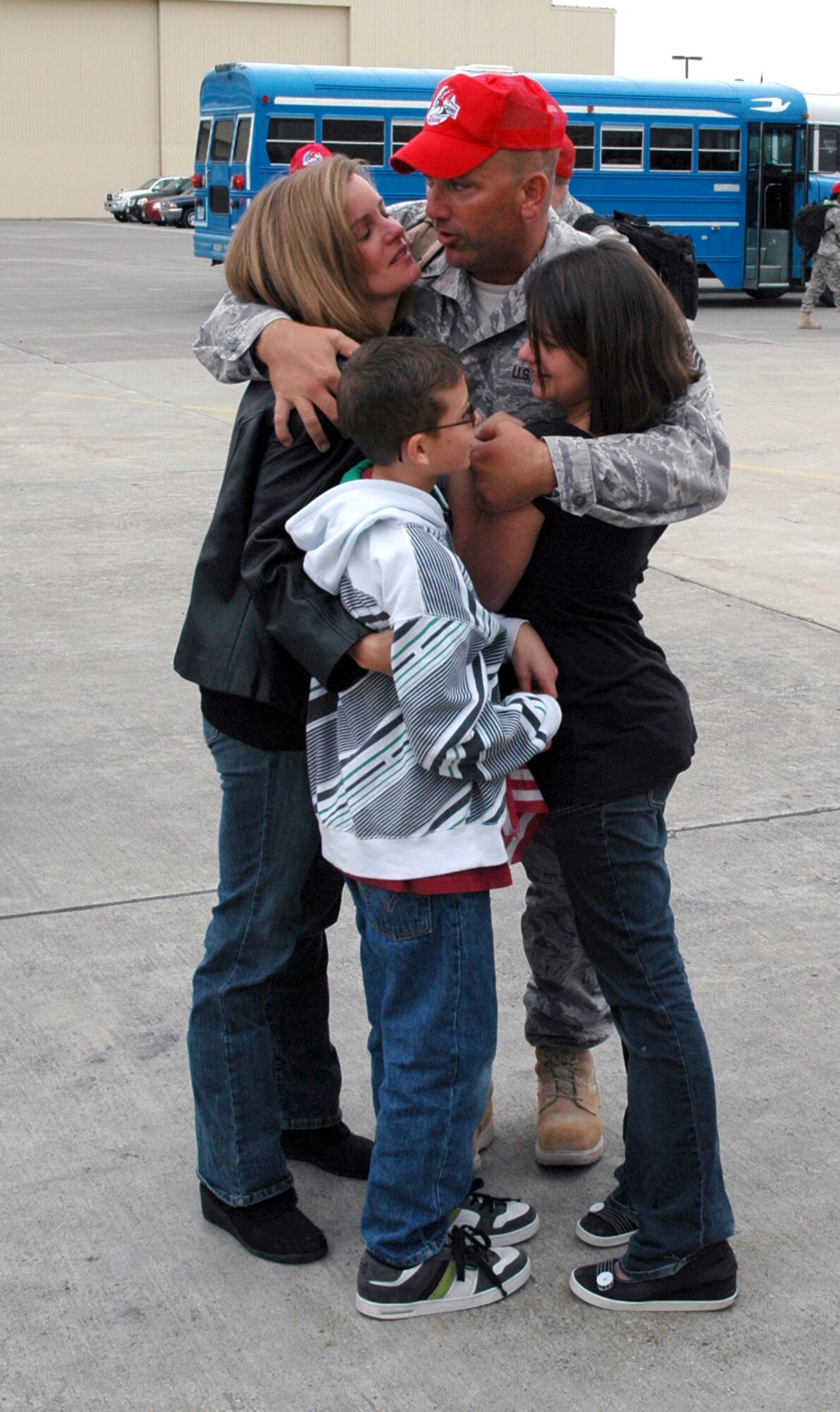 Master Sgt. Richard Hovik, 819th RED HORSE Squadron heavy equipment operator, hugs his wife Janea, daughter Alex, and son Christian, Oct. 11 near building 1460 following Sergeant Hovik's six-month deployment in support of operations in Iraq and Afghanistan. (U.S. Air Force photo/Senior Airman Dillon White)