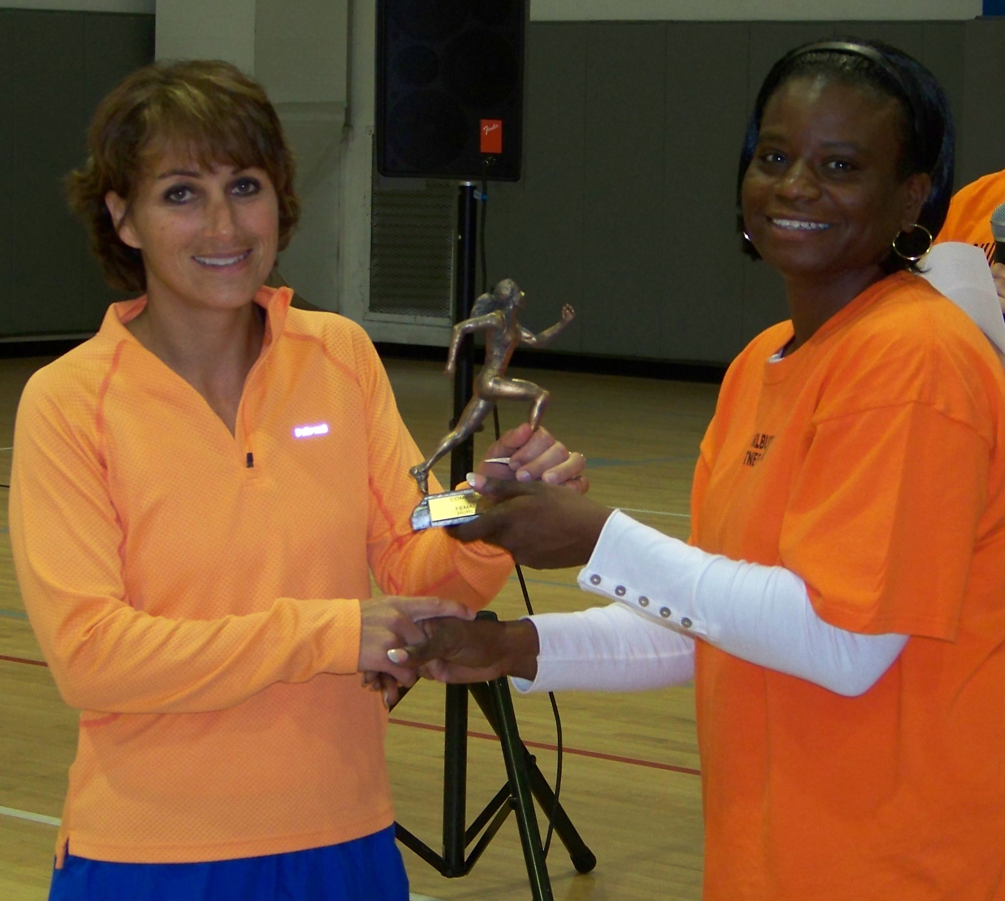 Master Sgt. Montrealle Parker, 1st Special Operations Force Support Squadron, right, presents a trophy for the best female runtime to Paula Piazza at the 5k Commando Run at the Aderholt Fitness Center at Hurlburt Field Oct. 17. Mrs. Piazza, who finished with a run time of 21:38, said it felt good to win today as she had won 1st place at a 5k run at Eglin Air Force Base the day before. (Air Force photo by Airman 1st Class Joe McFadden.)