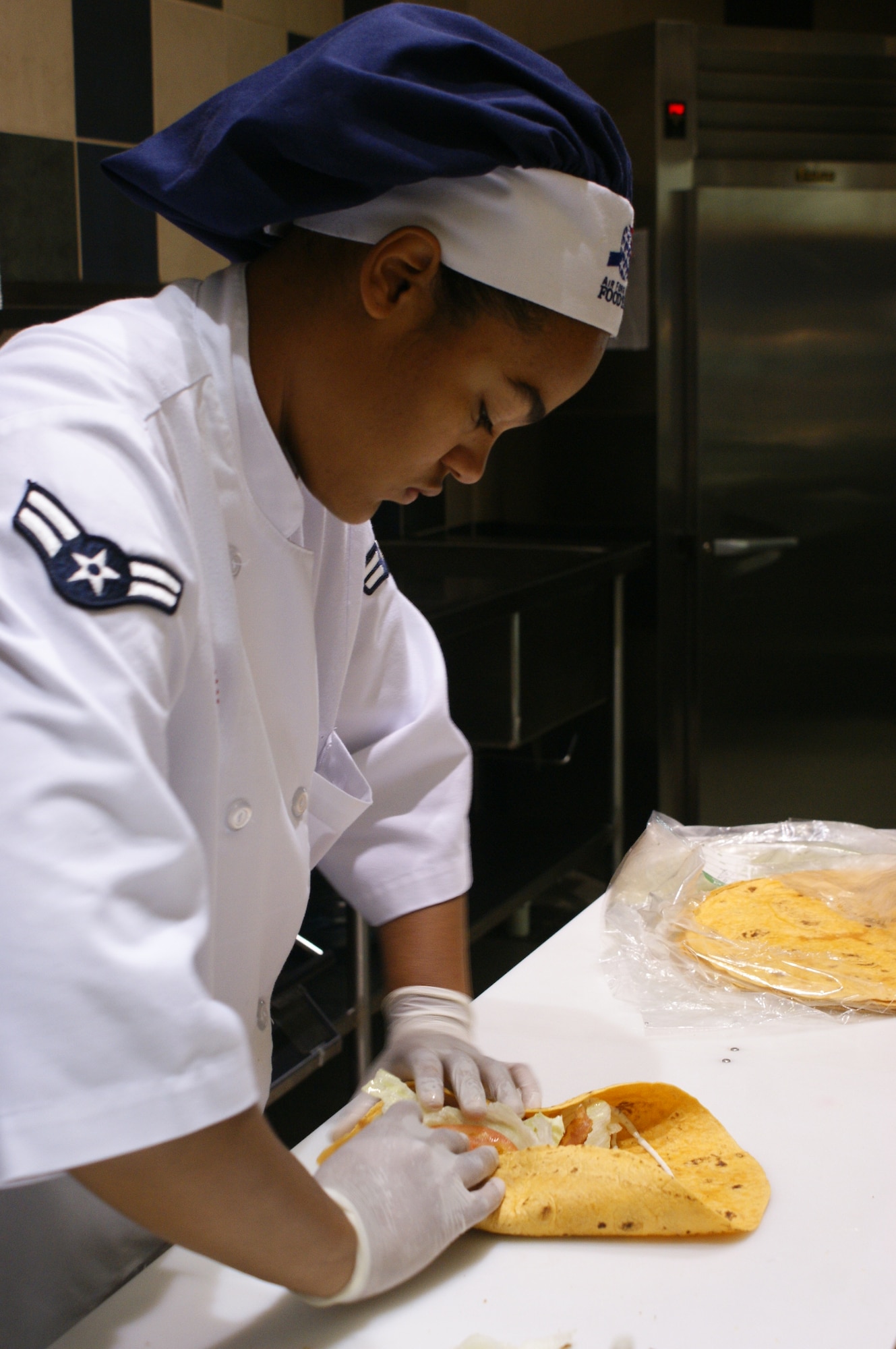 Airman 1st Class Chanel Smith, Hercules Dining facility food service apprentice, makes a wrap at the sandwich bar for a lunch patron Oct. 13. The dining facility is in the running to becoming Air Mobility Command’s nominee at Air Force-level for the John L. Hennessy award, given to the Air Force installation with the best food-service program. (Photos by Nicholasa Reed)