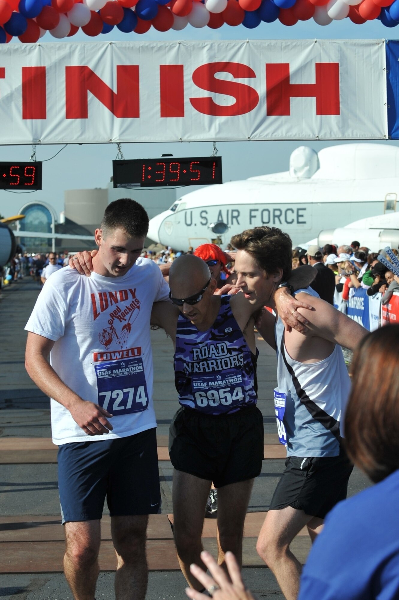 Master Sgt. Mike Sanders (center) gets some help from Second Lt. Evan McNichols (left) and Lieutenant McNichols' cousin, Ben, after finishing the U.S. Air Force Half Marathon at Wright Patterson Air Force Base, Ohio, Sept. 19.  Sergeant Sanders ran the event one year and eight months after beating cancer.  Then-Cadet McNichols was one of Sergeant Sanders' students when he served as an instructor with the University of Portland's Air Force Reserve Officer Training Corps program. (Photo courtesy Master Sgt. Mike Sanders.)