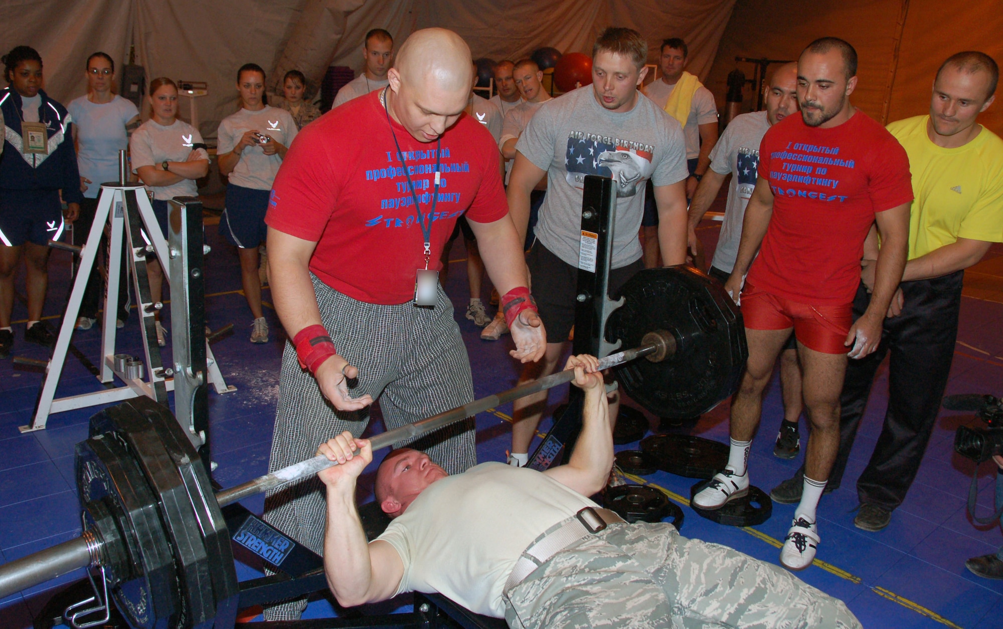 Senior Airman Mark Smith, 376th Expeditionary Aircraft Maintenance Squadron, bench presses twice his weight as Volkov Alexey, pro-athlete representing the Kyrgyz State Agency on Physical Culture and Sports, stands ready to spot him during a weightlifting competition between Airmen at the Transit Center at Manas and Kyrgyz athletes Oct. 18, 2009. The competition is the first of the events to foster more friendly sports relationships between the citizens of the two nations. (U.S. Air Force photo/Staff Sgt. Olufemi Owolabi)