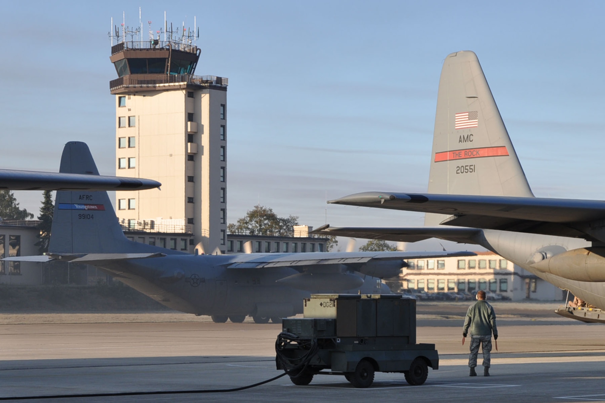 RAMSTEIN AIR BASE, Germany -- A C-130H Hercules tactical cargo transposrt aircraft assigned to the 910th Airlift Wing, based at Youngstown Air Reserve Station, Ohio, taxis by the flightline here prior to taking off on an airlift mission as a ground crew member looks on. The YARS C-130 and its crew are attached to the 38th Expeditionary Airlift Wing, base here, in support of Operation Joint Enterprise. More than 70 Airmen consisting of flight crews, maintenance personnel and support staff are currently attached to the 38th EAS with the airlift mission that will support destinations in the U.S. Europe Command (EUROCOM), the U.S. Africa Command (AFRICOM) and the U.S. Central Command (CENTCOM) theaters of operations. U.S. Air Force photo by Master Sgt. Bob Barko Jr.  