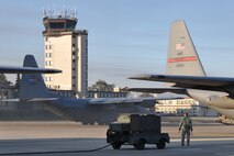 RAMSTEIN AIR BASE, Germany -- A C-130H Hercules tactical cargo transposrt aircraft assigned to the 910th Airlift Wing, based at Youngstown Air Reserve Station, Ohio, taxis by the flightline here prior to taking off on an airlift mission as a ground crew member looks on. The YARS C-130 and its crew are attached to the 38th Expeditionary Airlift Wing, base here, in support of Operation Joint Enterprise. More than 70 Airmen consisting of flight crews, maintenance personnel and support staff are currently attached to the 38th EAS with the airlift mission that will support destinations in the U.S. Europe Command (EUROCOM), the U.S. Africa Command (AFRICOM) and the U.S. Central Command (CENTCOM) theaters of operations. U.S. Air Force photo by Master Sgt. Bob Barko Jr.  