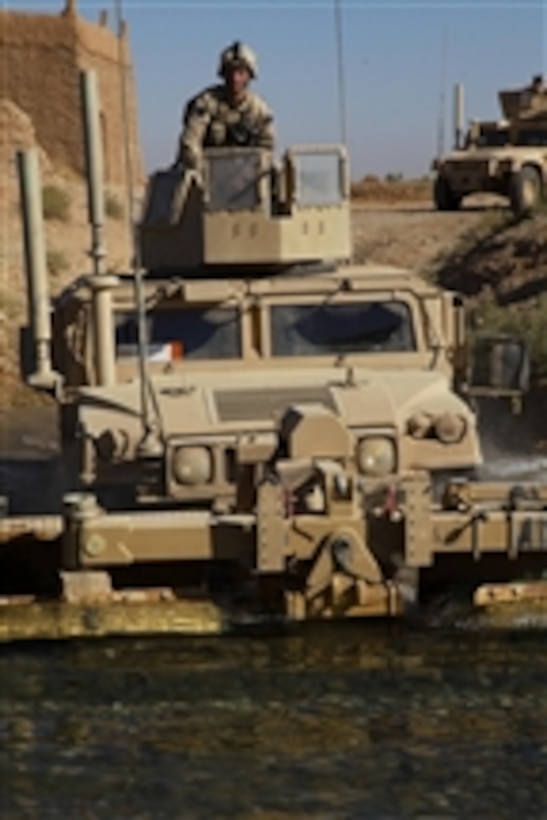 U.S. Marine Corps Cpl. Adam Boland, with Bravo Company, 1st Battalion, 5th Marine Regiment, rides in the turret of a Humvee while it crosses a stream during a security patrol through the Nawa district of Helmand province, Afghanistan, on Oct. 13, 2009.  Marines conduct security patrols to decrease insurgent activity and gain the trust of the people.  The Marines are deployed with Regimental Combat Team 3 to conduct counterinsurgency operations with Afghan National Security Forces in southern Afghanistan.  