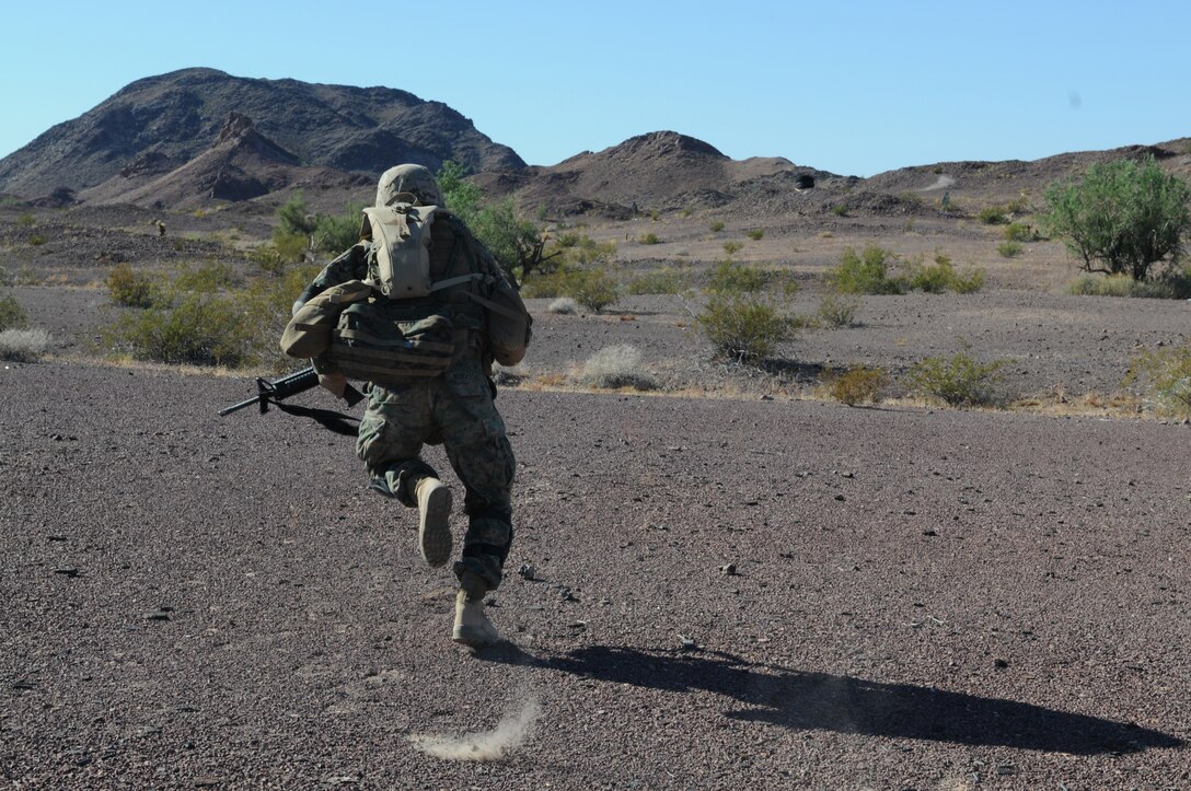 Lance Cpl. Ben Norville, an armory custodian with Headquarters and Service Company, 1st Battalion, 2nd Marine Regiment, sprints forward during infantry tactics training at Graze Range at the U.S. Army Yuma Proving Ground in Arizona, Oct. 18, 2009. Comprised of Marines with noninfantry specialties, the Camp Lejeune, N.C.-based company is preparing to operate as an infantry company during their upcoming deployment to Afghanistan in the spring of 2010.