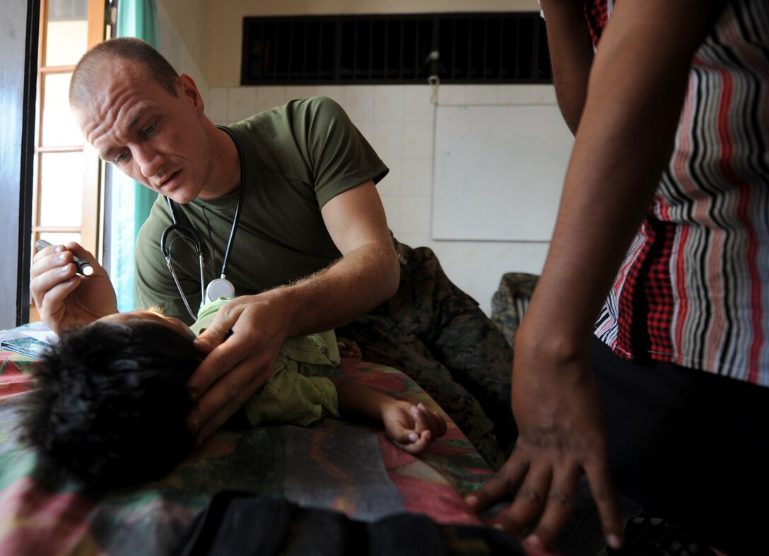 Navy Lt. Stephen Zanoni, a Milwaukee, Wis. native, performs an exam on a young boy at a clinic here Oct. 19. Zanoni and other medical personnel from the 11th Marine Expeditionary Unit provided medical and dental care to more than 500 people since arriving in Timor Leste Oct. 14. Zanoni is a general medical officer with the unit.