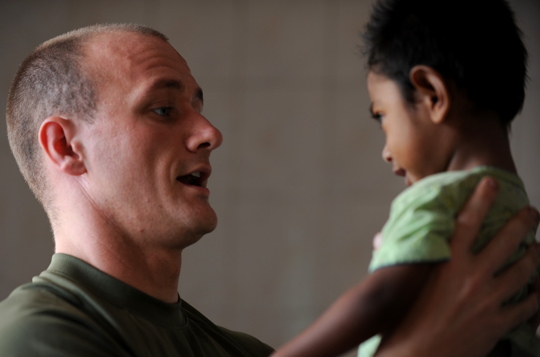 Navy Lt. Stephen Zanoni, a Milwaukee, Wis. native, examines a young boy at a clinic here Oct. 19. Zanoni, a general medical officer with the 11th Marine Expeditionary Unit, is part of a medical team providing health services to the people of Timor Leste.