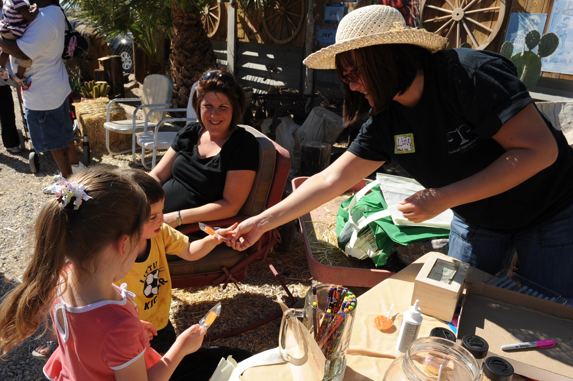 LAS VEGAS, Nev.--Tech. Sgt. Lisa Lee, a 926th Group paralegal, hands out candy to some local children at the Fall Pumpkin Patch at The Farm, Oct. 17, 2009. Several Airmen from Nellis Air Force Base volunteered at The Farm to help the farm owners maintain activities like the Fall Pumpkin Patch and eventually expand the area where The Farm is located.
(U.S. Air Force Photo by Airman 1st Class Jamie Nicley)