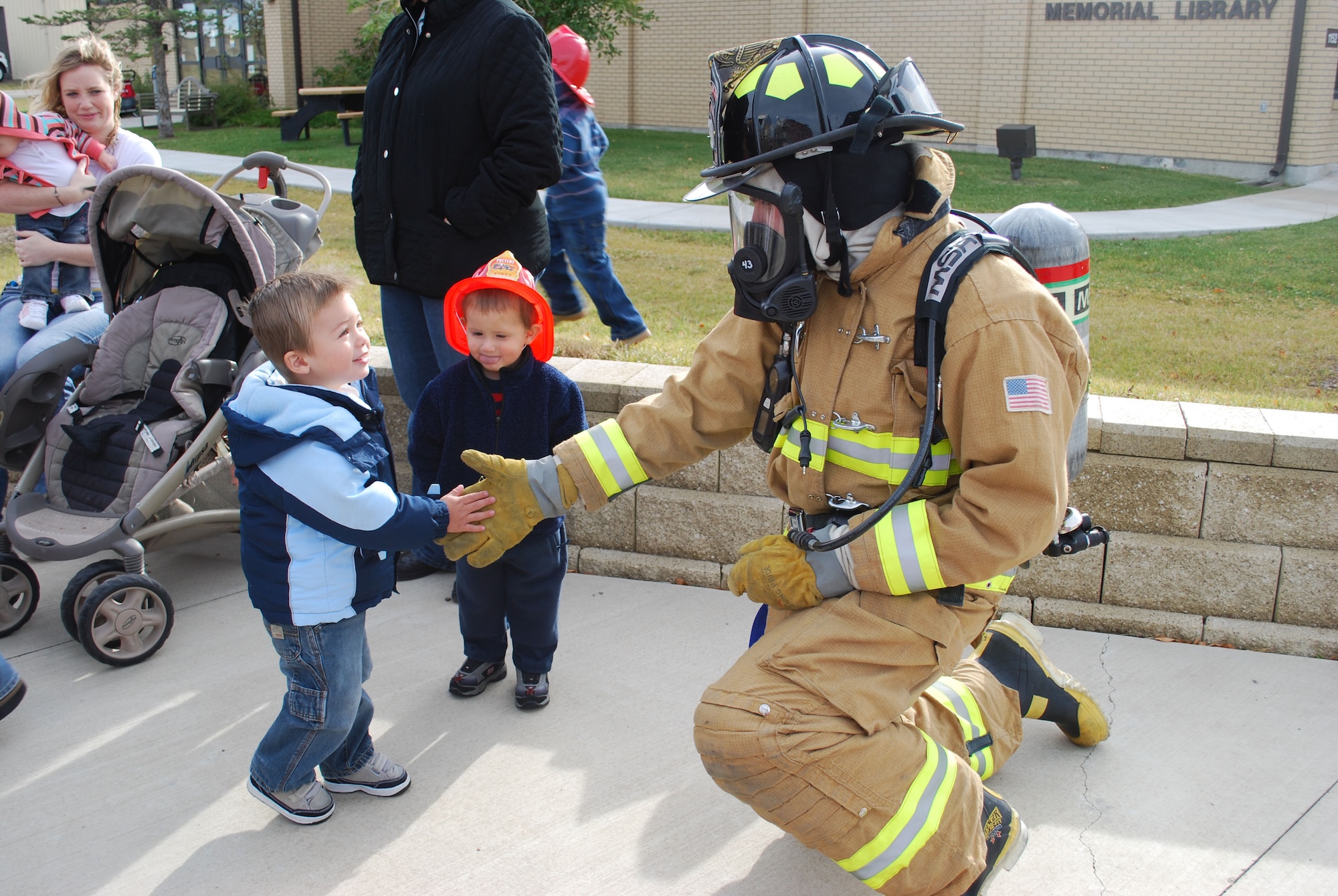 David, 2, shakes hands with Airman 1st Class Ryan McCann, 341st Civil Engineer Squadron fire fighter, outside the base library Oct. 6.  Sparky The Fire Dog and a crew of fire fighters were the special guests during National Fire Prevent Week Oct. 4 to 9. This year's theme is "Stay Fire Smart! Don't Get Burned!"  (U.S. Air Force photo/Staff Sgt. Eydie Sakura)