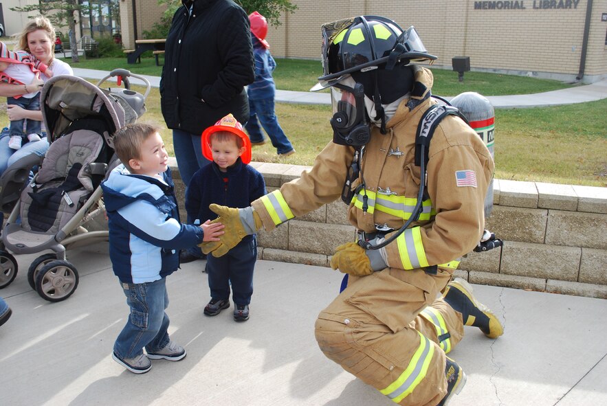 David, 2, shakes hands with Airman 1st Class Ryan McCann, 341st Civil Engineer Squadron fire fighter, outside the base library Oct. 6.  Sparky The Fire Dog and a crew of fire fighters were the special guests during National Fire Prevent Week Oct. 4 to 9. This year's theme is "Stay Fire Smart! Don't Get Burned!"  (U.S. Air Force photo/Staff Sgt. Eydie Sakura)