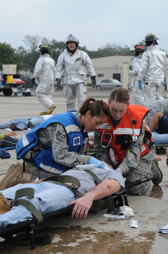 Senior Airman Christela Turner (left) and Airman 1st Class Charis Becker, 12 Medical Group flight medicine technicians, perform medical care on a simulated victim of the Air Show Exercise at Randolph Air Force Base Oct. 14.
