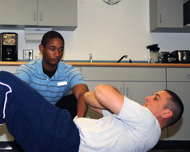 WHITEMAN AIR FORCE BASE, Mo. -- Nathan Berkley, a student intern at the Whiteman Health and Wellness Center, observes situps performed by Senior Master Sgt. Samuel Simmons, Superintendant, 509th Operations Support Squadron.  The duo demonstrated proper situp form at a Physical Training Leader refresher course, Monday.
(U.S. Air Force Photo/Airman 1st Class Torey Griffith)