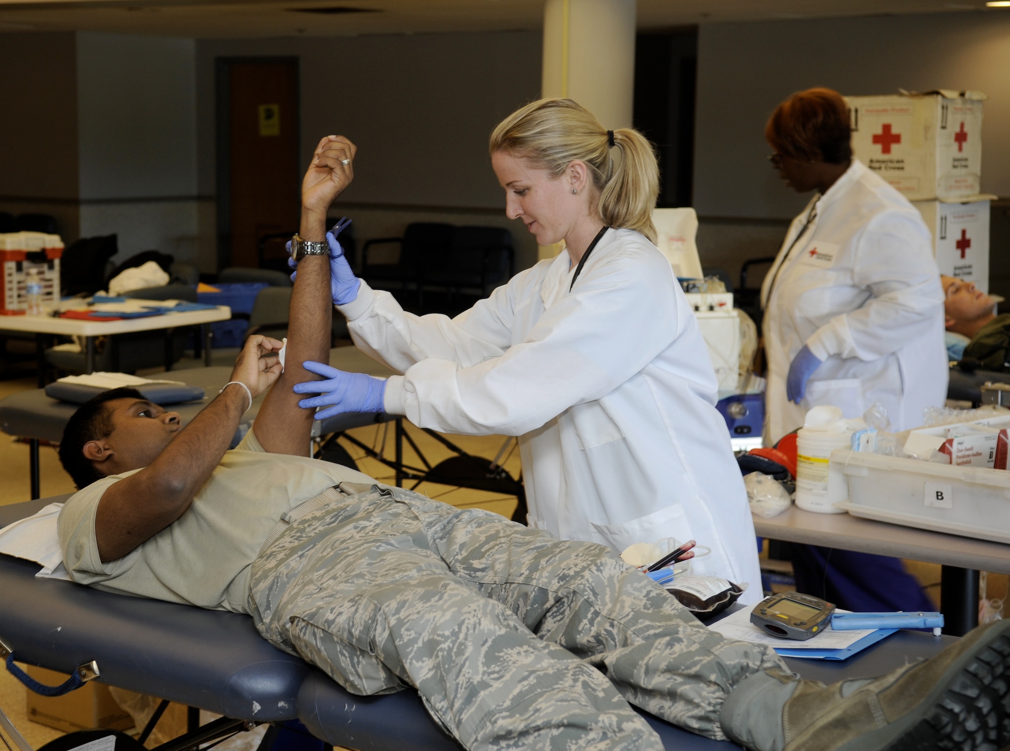 Air Force Staff Sgt. Dhamindra Parakrama, 87th Medical Squadron computer systems technician, donates blood during a blood drive here Oct. 19. Jennifer Sacalis, a Red Cross donation assistant and registered nurse, holds Staff Sgt. Parakrama’s arm up after removing the needle to make sure no bleeding occurs.  (U.S. Air Force photo/Carlos Cintron)
