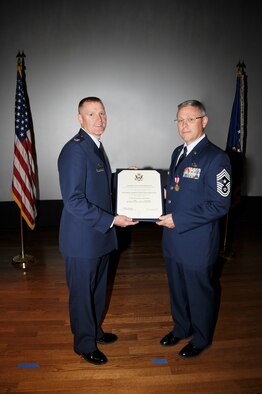 Chief Master Sergeant Whitenburg receives his retirement certificate from Colonel Lewis