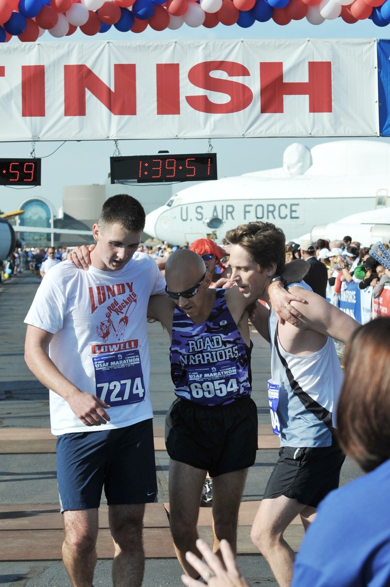Master Sgt. Mike Sanders (center) gets some help from 2nd Lt. Evan McNichols (left) and Lieutenant McNichols' cousin, Ben, after finishing the Air Force Half Marathon Sept. 19, 2009, at Wright-Patterson Air Force Base, Ohio. Sergeant Sanders ran the event one year and eight months after beating cancer. Sergeant Sanders had served as an instructor with the University of Oregon's Air Force ROTC program, and Lieutenant McNichols was a cadet there and they have been each other's wingman since. (Courtesy photo)