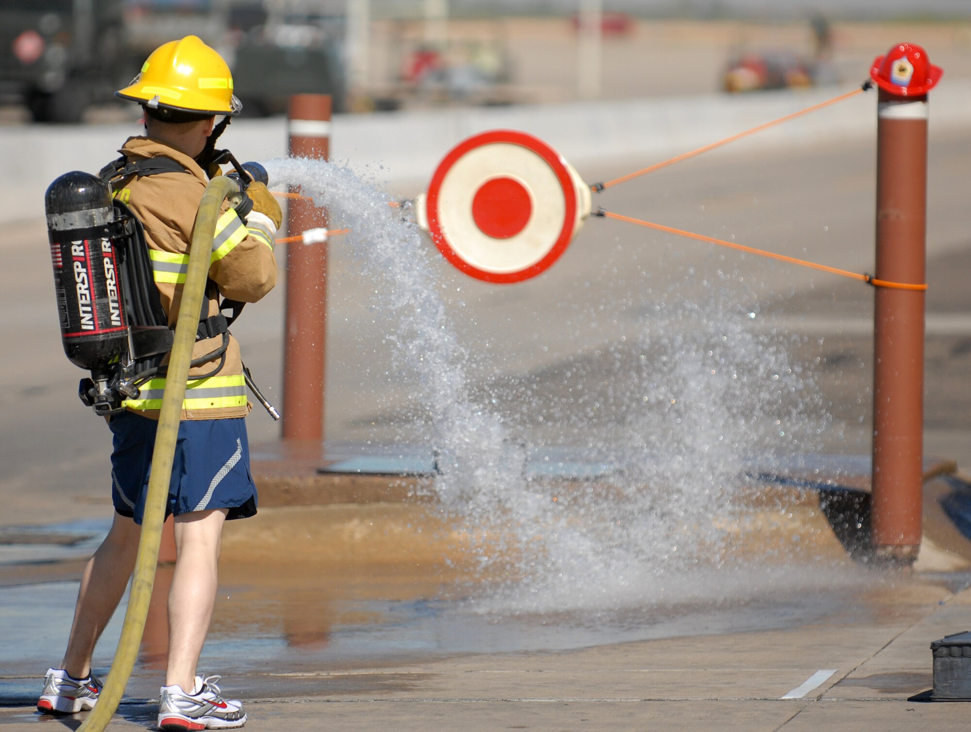 Airman 1st Class Richard Phernetton, 56th Civil Engineer Squadron engineering apprentice, sprays the target with a charged fire hose during the Firefighter Combat Challenge held at the Luke Air Force Base Fire Station, October 16, 2009. (U.S. Air Force photo by Airman 1st Class Sandra Welch)  