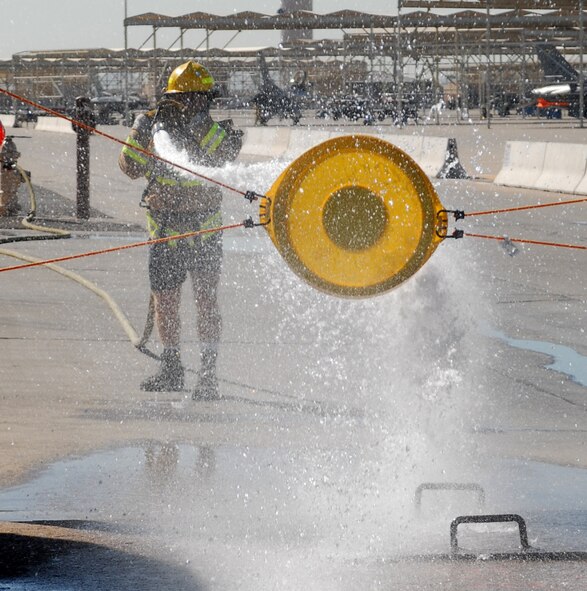 Lieutenant Colonel James McCune, 310th Fighter Squadron squadron commander, shoots the target with a charged fire hose during the Firefighter Combat Challenge held at the Luke Air Force Base Fire Station, October 16, 2009. (U.S. Air Force photo by Airman 1st Class Sandra Welch)  