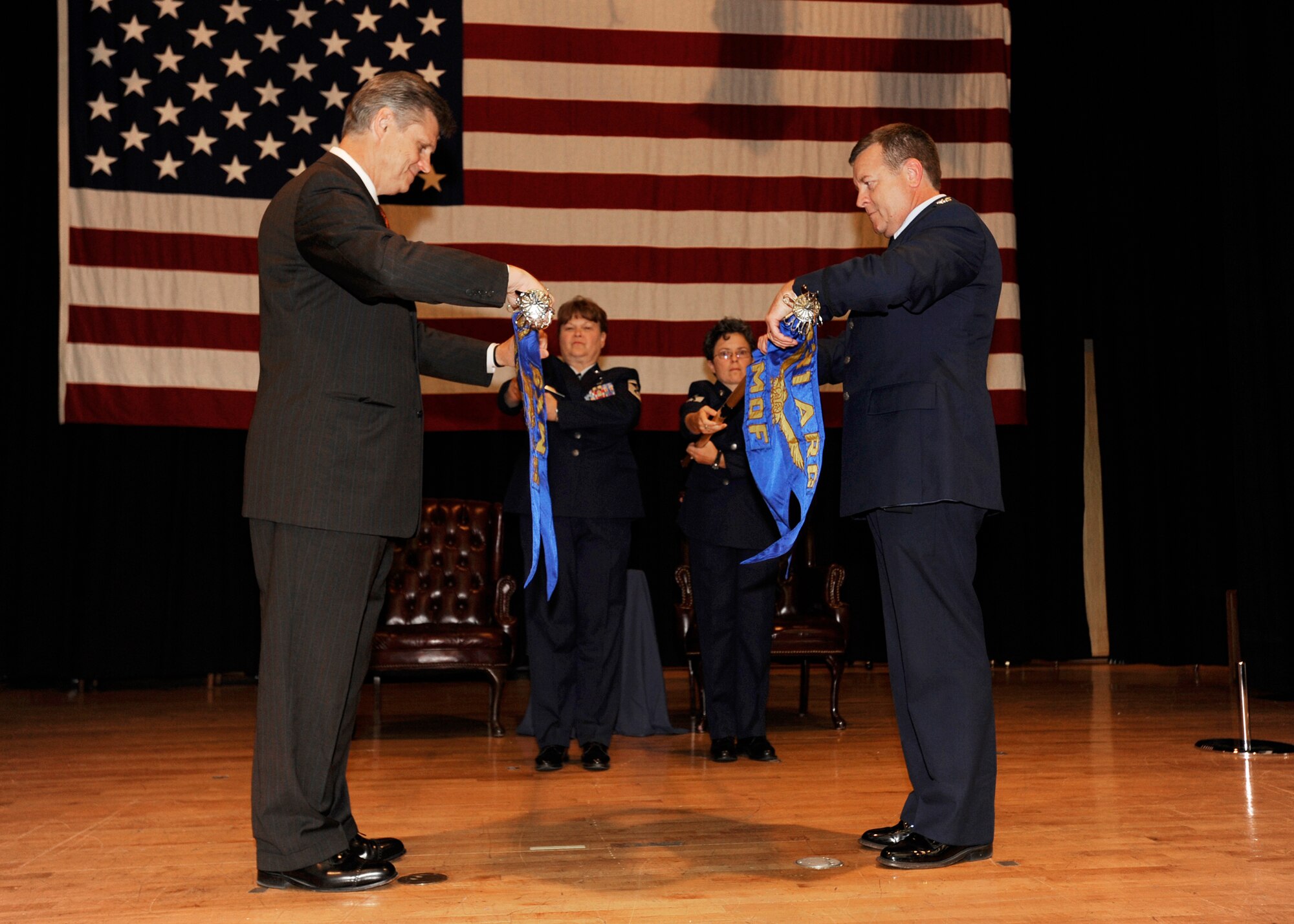 U.S. Rep. Todd Tiahrt, R-Goddard, and Col. Edsel "Archie" Frye Jr. unravel guidons of two new 931st Air Refueling Group units during a ribbon cutting ceremony at McConnell Air Force Base, Kan. New commanders assumed command of the units, the 931st Maintenance Squadron and the 931st Maintenance Operations Flight, during another ceremony that soon followed. Colonel Frye is commander of the 931st ARG, an Air Force Reserve unit. (U.S. Air Force photo/Staff Sgt. Jaime Train)