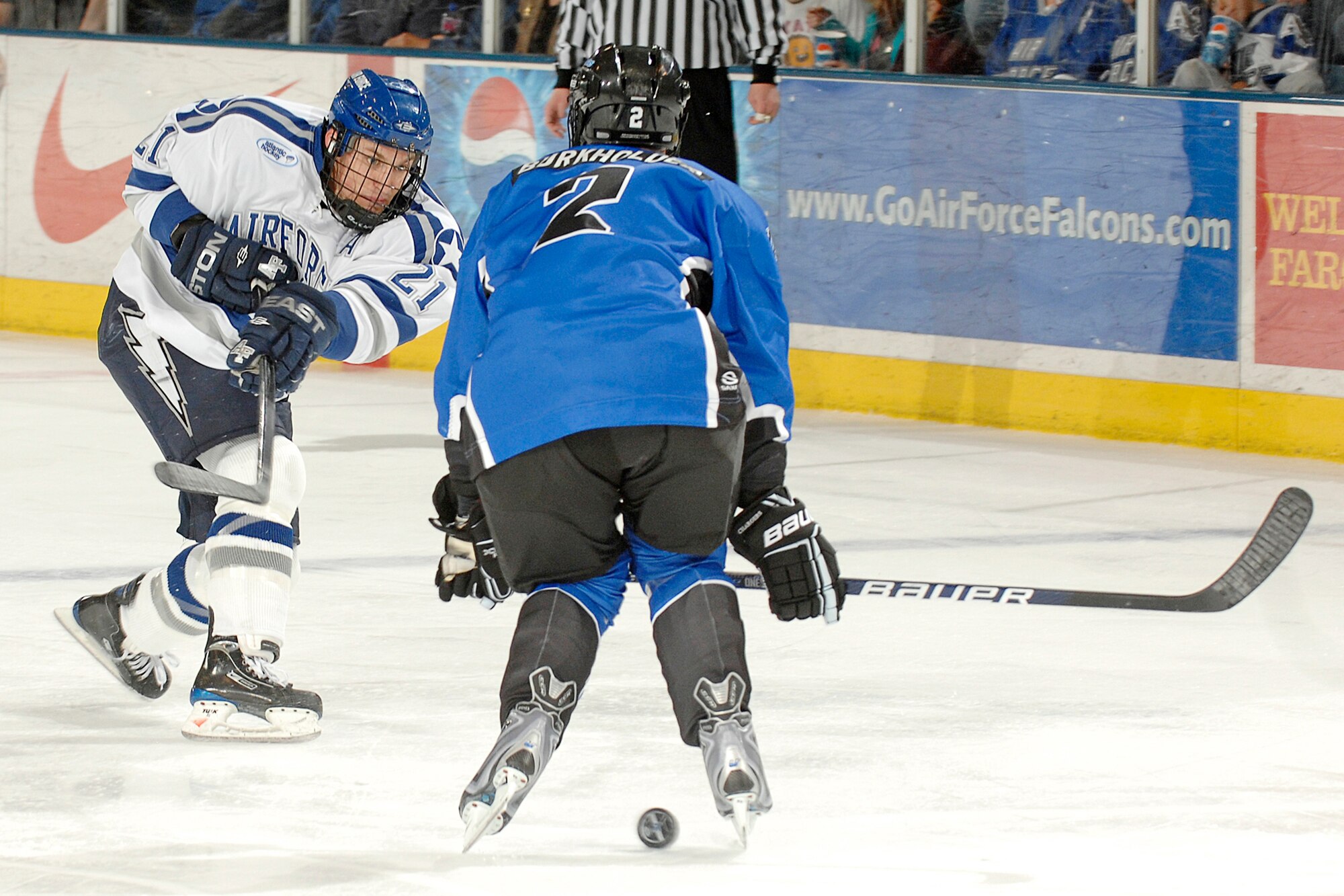 Falcon junior Jacques Lamoureux takes a shot through the legs of opponent Ryan Burkholder in the University of Alabama-Huntsville game at the U.S. Air Force Academy Cadet Ice Arena Oct 17, 2009.  The UAH Chargers held off the Falcons for a 4-2 win. (U.S. Air Force photo/Mike Kaplan)