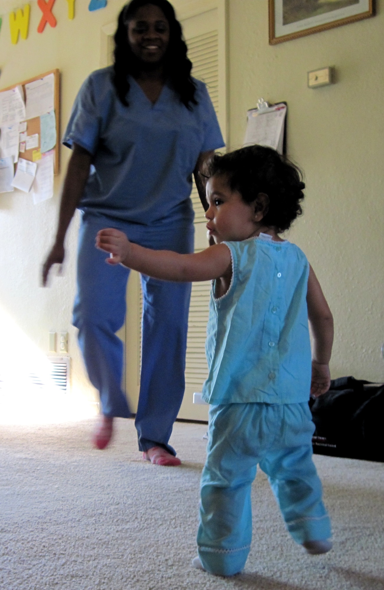 Alexandria Mireles dances to her favorite show "Hip Hop Harry" with the supervision of her Family Child Care provider, Erica Russell, Oct. 20. Early September, Ms. Russell used her life-saving CPR skills to assist the 18-month old after the girl stopped breathing. Emergency technicians and Alexandria's parents said Ms. Russell saved the girl's life after a high fever put her into seizure. Eglin licenses FCC providers and provides essential training like CPR prior to certification. (U.S. Air Force photo/Chrissy Cuttita)