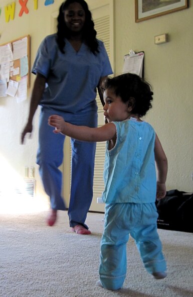 Alexandria Mireles dances to her favorite show "Hip Hop Harry" with the supervision of her Family Child Care provider, Erica Russell, Oct. 20. Early September, Ms. Russell used her life-saving CPR skills to assist the 18-month old after the girl stopped breathing. Emergency technicians and Alexandria's parents said Ms. Russell saved the girl's life after a high fever put her into seizure. Eglin licenses FCC providers and provides essential training like CPR prior to certification. (U.S. Air Force photo/Chrissy Cuttita)