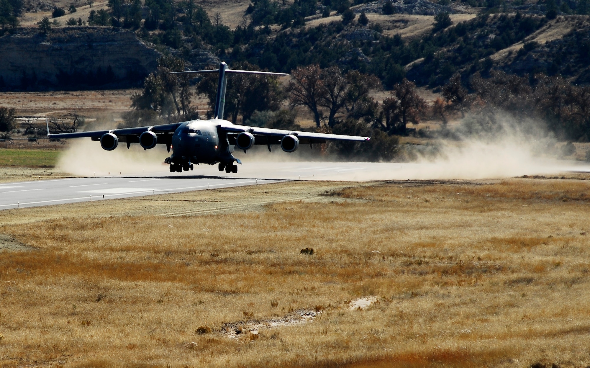 A C-17 Globemaster III aircraft from McChord lands at the Wyoming National Guard's Guernsey Army Airfield at Camp Guernsey in Guernsey, Wyo., during the official opening of an updated airstrip capable of handling the massive cargo aircraft. The airstrip is now capable of supporting up to 20 fixed-wing aircraft as well as three C-17's. In addition to the civilian/military air strip, Camp Guernsey also boasts nearly 70,000 acres of terrain and supports approximately 65 square miles of restricted air space up to 30,000 feet. (Photo by Brandon Quester/Public Affairs Specialist/Wyoming National Guard).