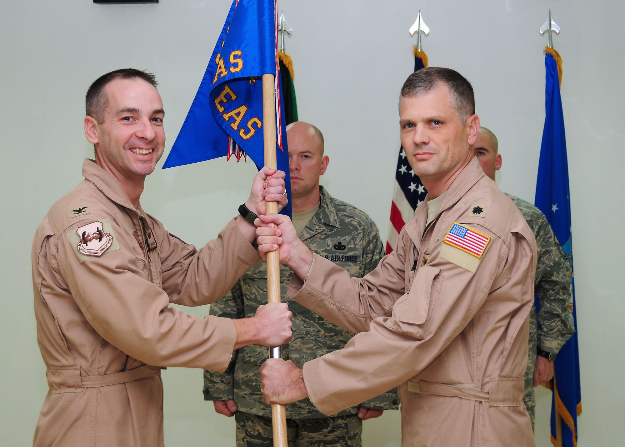 SOUTHWEST ASIA -- Lt. Col. George Clark assumes command of the 737th Expeditionary Airlift Squadron, by accepting the guidon from Col. Mark Czelusta, 386th Expeditionary Operations Group commander, during a change of command ceremony at an airbase in Southwest Asia Oct. 19, 2009.  (U.S. Air Force photo/Tech. Sgt. Tony Tolley)