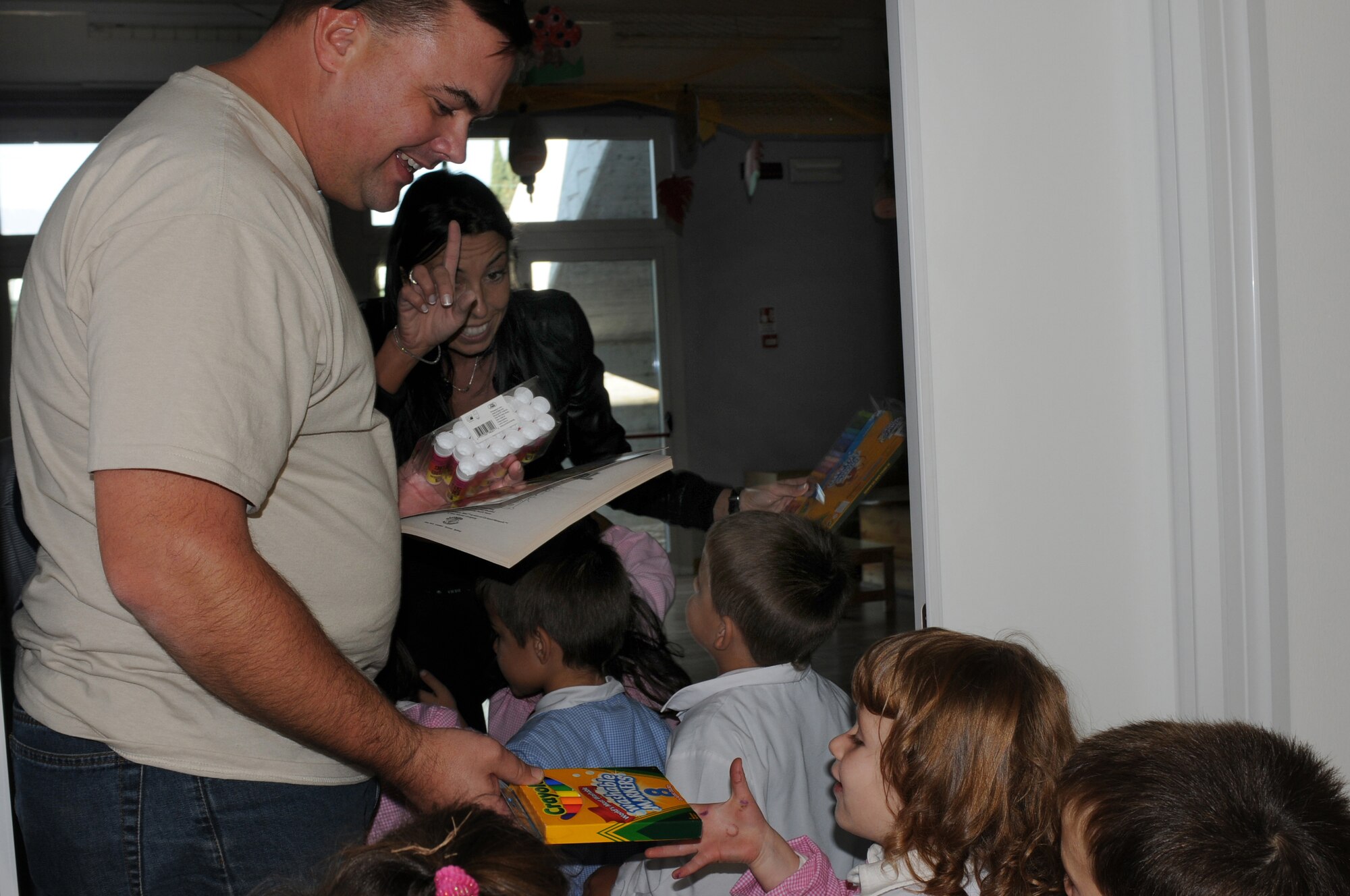 Master Sgt. Eric Clark, 603rd Air Control Squadron NCO in charge of quality assurance, hands out donated school supplies to children of a local Italian elementary school Oct. 16, 2009 in San Quirino, Italy. Members of the 603rd ACS volunteered 60 hours of their time assisting the school with various beautification projects. (U.S. Air Force photo/ Senior Airman Nadine Y. Barclay)
