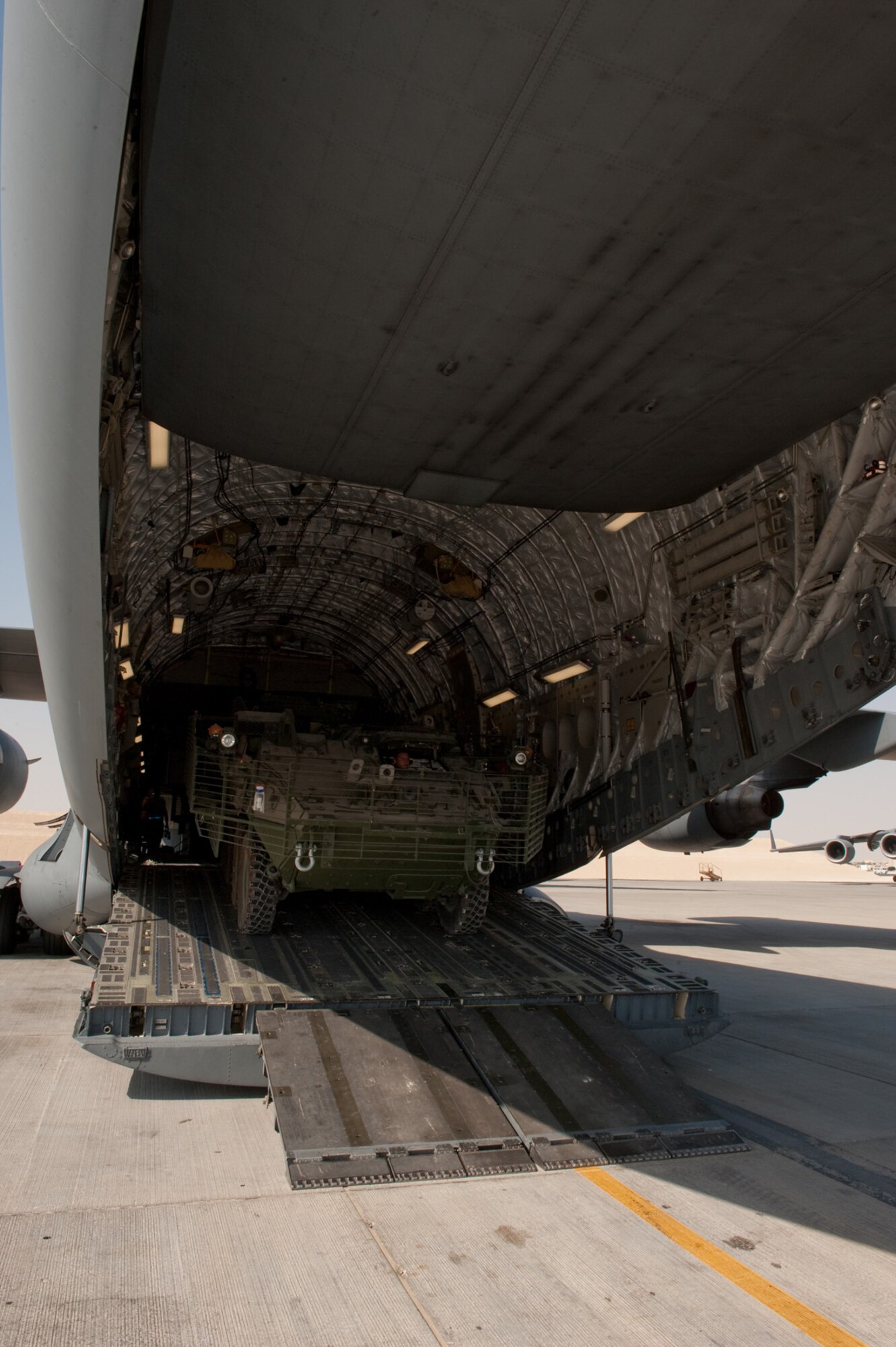 Airman Daniel Webb, 8th Expeditionary Air Mobility Squadron, parks a Stryker M1126 Infantry Carrier Vehicle as he loads it onto a C-17 Globemaster III, Oct. 17, 2009, in Southwest Asia. Airman Webb, along with fellow 8 EAMS ramp section members, helps load and unload all cargo, including Stryker ICVs, for local aircraft. Airman Webb is deployed from Altus Air Force Base, Okla., in support of operations Iraqi Freedom and Enduring Freedom. (U.S. Air Force photo/Staff Sgt. Robert Barney) 