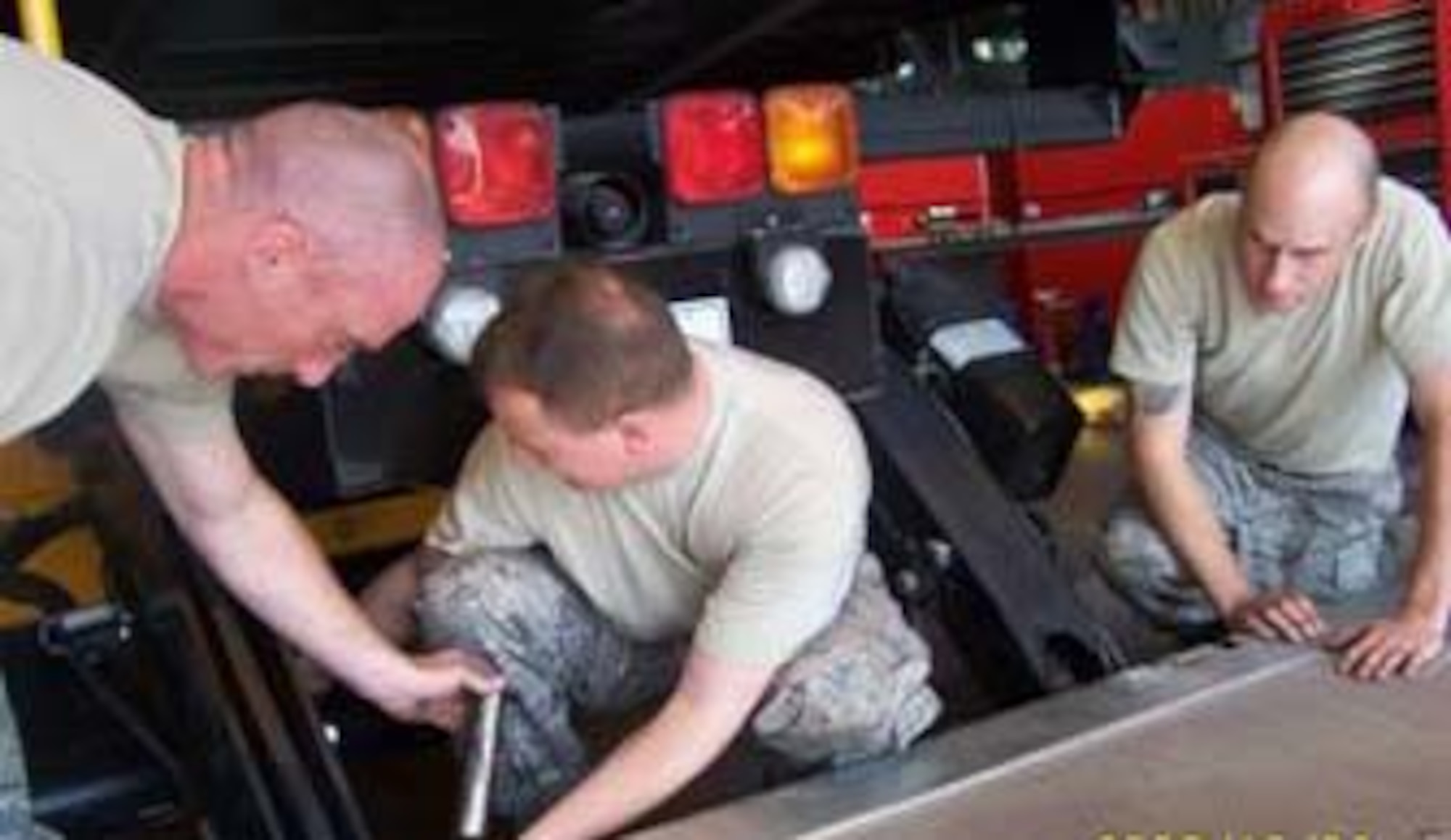 From left to right, Master Sgt. Steven Riggs, Tech. Sgt. Ronald Coulter and Staff Sgt. Timothy Thompson, 86th Vehicle Readiness Squadron maintainers, reinstall the patient platform on the generation two high deck patient loading platform vehicle. The HDPLP was an Air Force idea to help give better care to wounded warriors. (Courtesy photo)