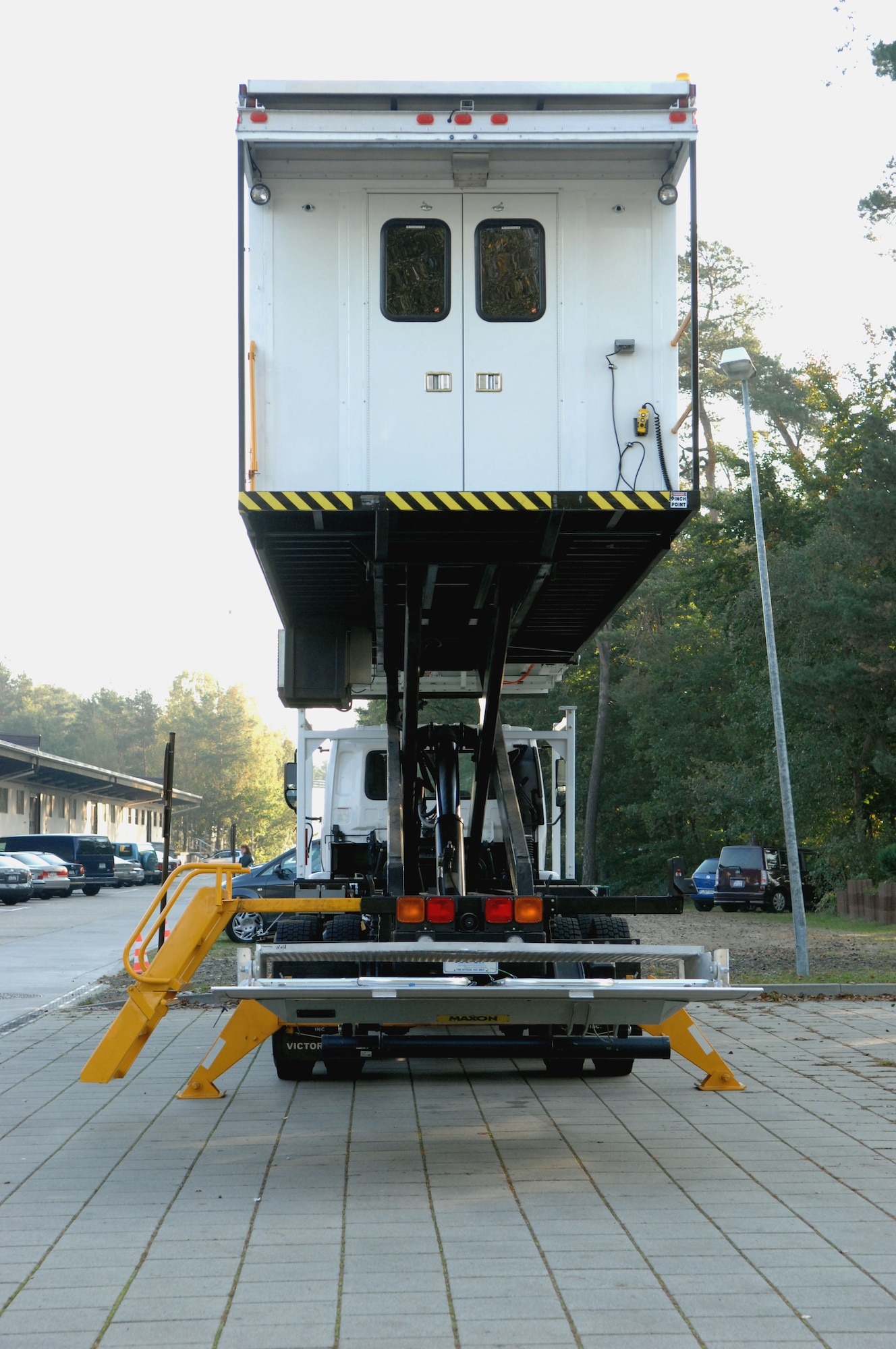 The high deck patient loading platform vehicle, or HDPLP, sits in a raised position to show the scissor-lift underneath the vehicle. The HDPLP was an Air Force idea to help give better care to wounded warriors. By taking a vehicle frame and adding modifications, the Air Force was able to modernize a standard vehicle for warrior care while allowing for base vehicle maintenance squadrons to sustain the required standards for operations, Ramstein Air Base, Germany. (U.S. Air Force photo by Airman 1st Class Brittany Perry)