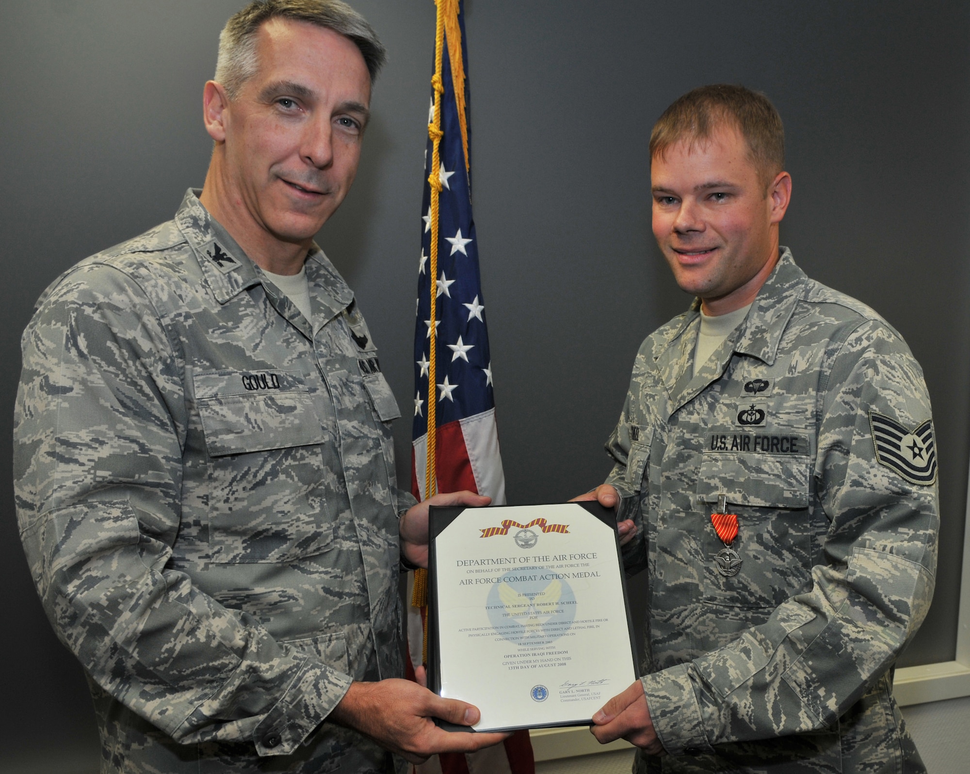 U.S. Air Force Col. Thomas F. Gould, 435th Air Ground Operations Wing commander, left, presents the Air Force Combat Action Medal to Tech. Sgt. Robert Scheel, 7th Weather Squadron battlefield weather forecaster, Oct. 14, 2009, Ramstein Air Base, Germany. Sergeant Scheel was awarded the Combat Action Medal after his ground convoy was engaged by enemy forces necessitating an immediate response of direct and lethal fire. (U.S. Air Force photo by Senior Airman Nathan Lipscomb)