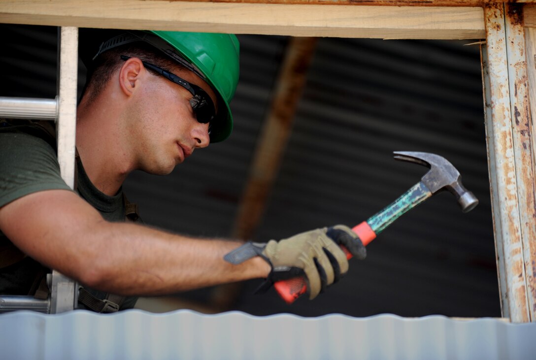 Lance Cpl. Michael Denovio, from Burnt Hills, N.Y., installs wooden vents at a school here Oct. 20 during an engineering project. Marines with Combat Logistics Battalion 11, 11th Marine Expeditionary Unit, removed thatch roofing and bamboo walls from the structure and installed metal roofing and siding. Members of the 11th MEU are in Timor Leste for an exercise focused on medical and dental assistance, engineering projects and military interaction. Denovio is a heavy equipment operator with the battalion.