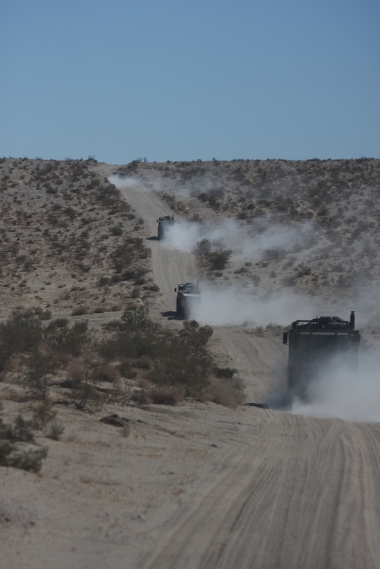 A convoy from Combat Logistics Battalion 7 drives along the dirt roads of the Combat Center laden with trash from the 1st Light Armored Reconnaissance Battalion after delivering water, fuel, parts and ice to them Oct. 21.