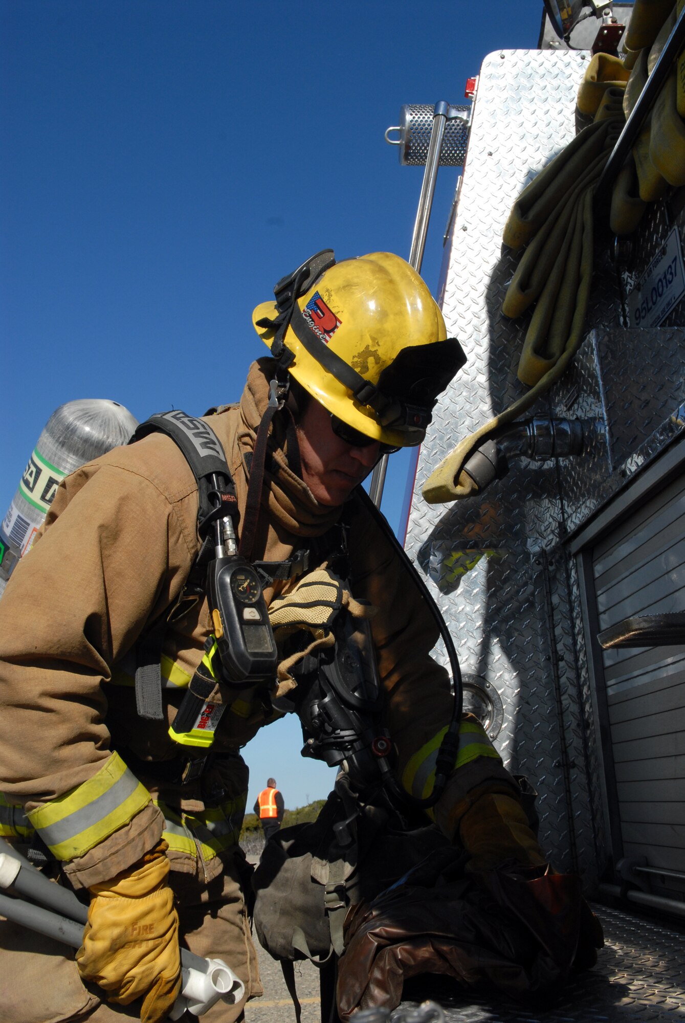 VANDENBERG AIR FORCE BASE, Calif. - In preparation to set up a decontamination pool, civilian firefighter Andrew Klein, grabs his gear for the next phase of an exercise here Tuesday, Oct. 20, 2009. The annual Emergency Operations Staff Assistant Visit was preformed as a preparation for the yearly visit of the Inspector General. (U.S. Air Force photo/Airman 1st Class Angelina Drake)
