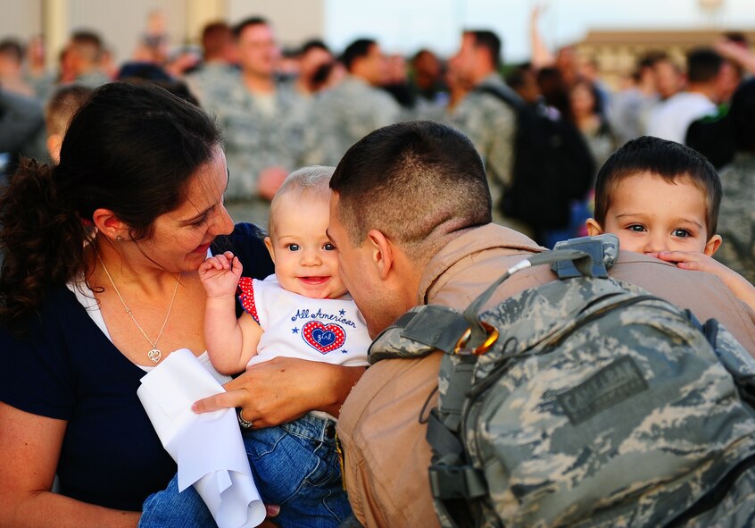 DYESS AIR FORCE BASE, Texas -- Captain Mark Berthelotte, his wife Allyssa and their two children Willem (two) and Maren (eight months) embrace each other here Oct. 20.  Captain Berthelotte just returned from a six month deployment to Ali Al Salem Air Base, Kuwait. (U.S. Air Force photo by Senior Airman Stephen Reyes)