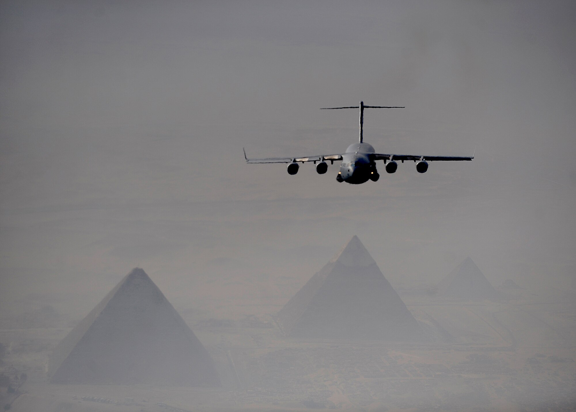 A C-17 Globemaster III flies over Cairo with the Pyramids of Giza in the distance Oct. 15, 2009 during Exercise Bright Star. Bright Star is a joint international military airdrop exercise that strengthens and enhances the cohesiveness of each country's participating forces. The C-17 crew is from the 437th Airlift Wing at Charleston Air Force Base, S.C.  (U.S. Air Force photo/Staff Sgt. Jacob N. Bailey)