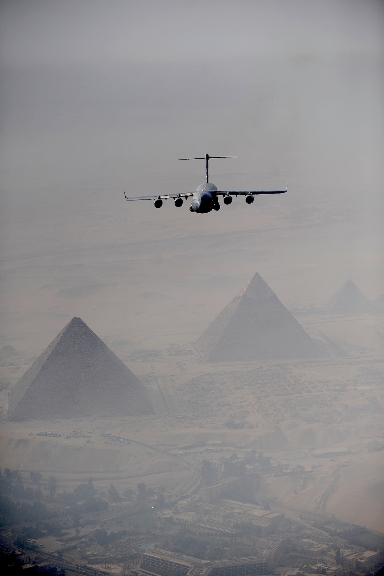 A C-17 Globemaster III flies over Cairo with the Pyramids of Giza in the distance Oct. 15, 2009 during Exercise Bright Star. Bright Star is a joint international military airdrop exercise that strengthens and enhances the cohesiveness of each country's participating forces. The C-17 crew is from the 437th Airlift Wing at Charleston Air Force Base, S.C.  (U.S. Air Force photo/Staff Sgt. Jacob N. Bailey)