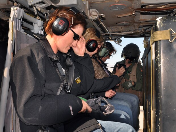 NELLIS AIR FORCE BASE, Nev.-- Senior Airman Phillip Bradbury, 66th Rescue Squadron flight engineer, assists spouses with safety belts inside the HH-60G Pavehawk during the spouse orientation day Oct. 16, 2009.  Spouses of the 66th RQS, 58th RQS and 763rd Maintenance Squadron participated in orientation flights to become familiar with the training and the mission of the units.
(U.S Air Force Photo by Airman 1st Class Stephanie Rubi)