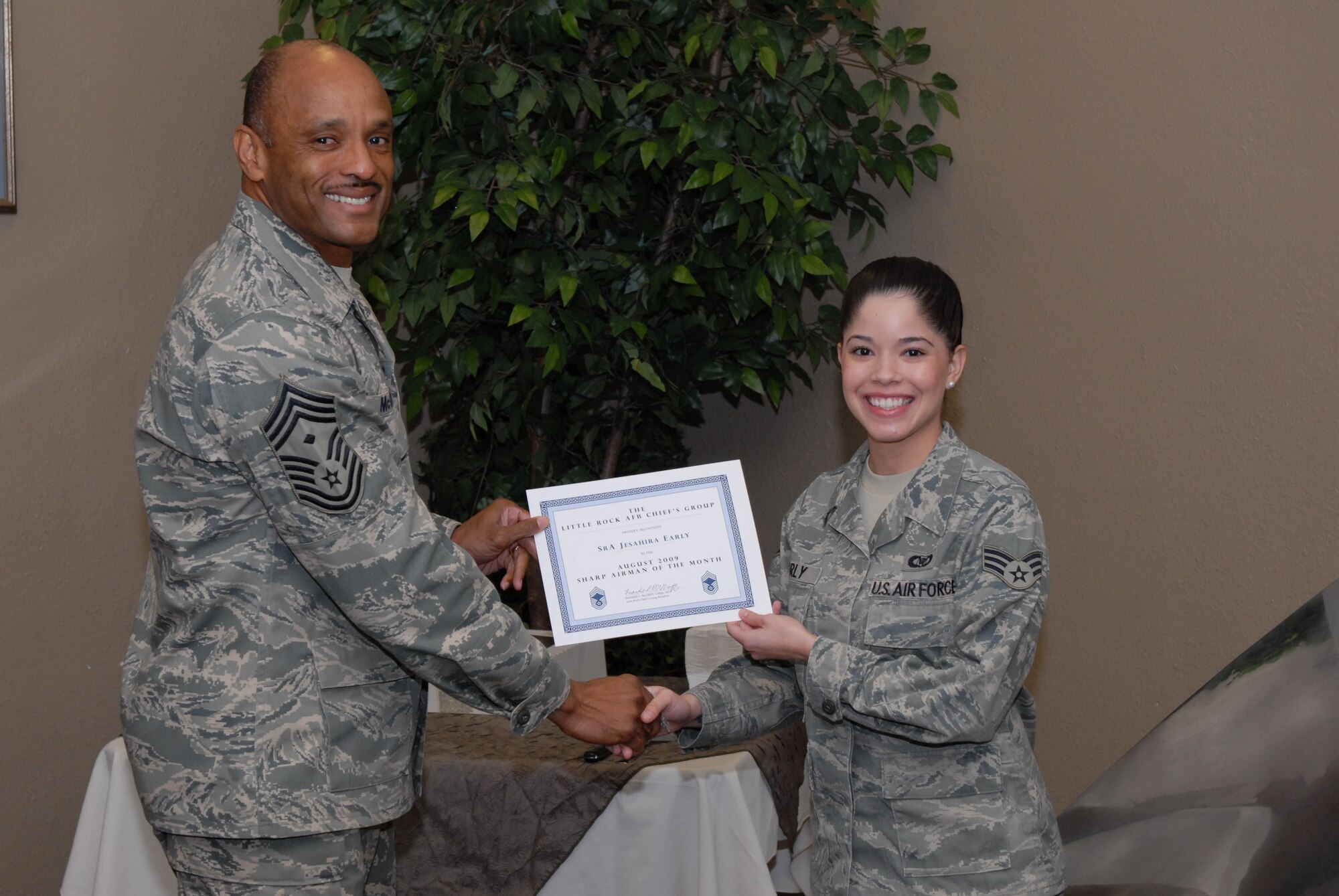 Chief Master Sgt. Frankie McGriff, 19th Equipment Maintenance Squadron superintendent, presents Senior Airman Jesahira Early, a 53rd Airlift Squadron aviation resource manager, with the Chief's Sharp Troop Award at Hangar 1080 Oct. 20. The Chief's Sharp Troop award is given to Airmen who set themselves apart through their outstanding Airmanship and accomplishments. (U.S. Air Force photo by Senior Airman Nathan Allen)