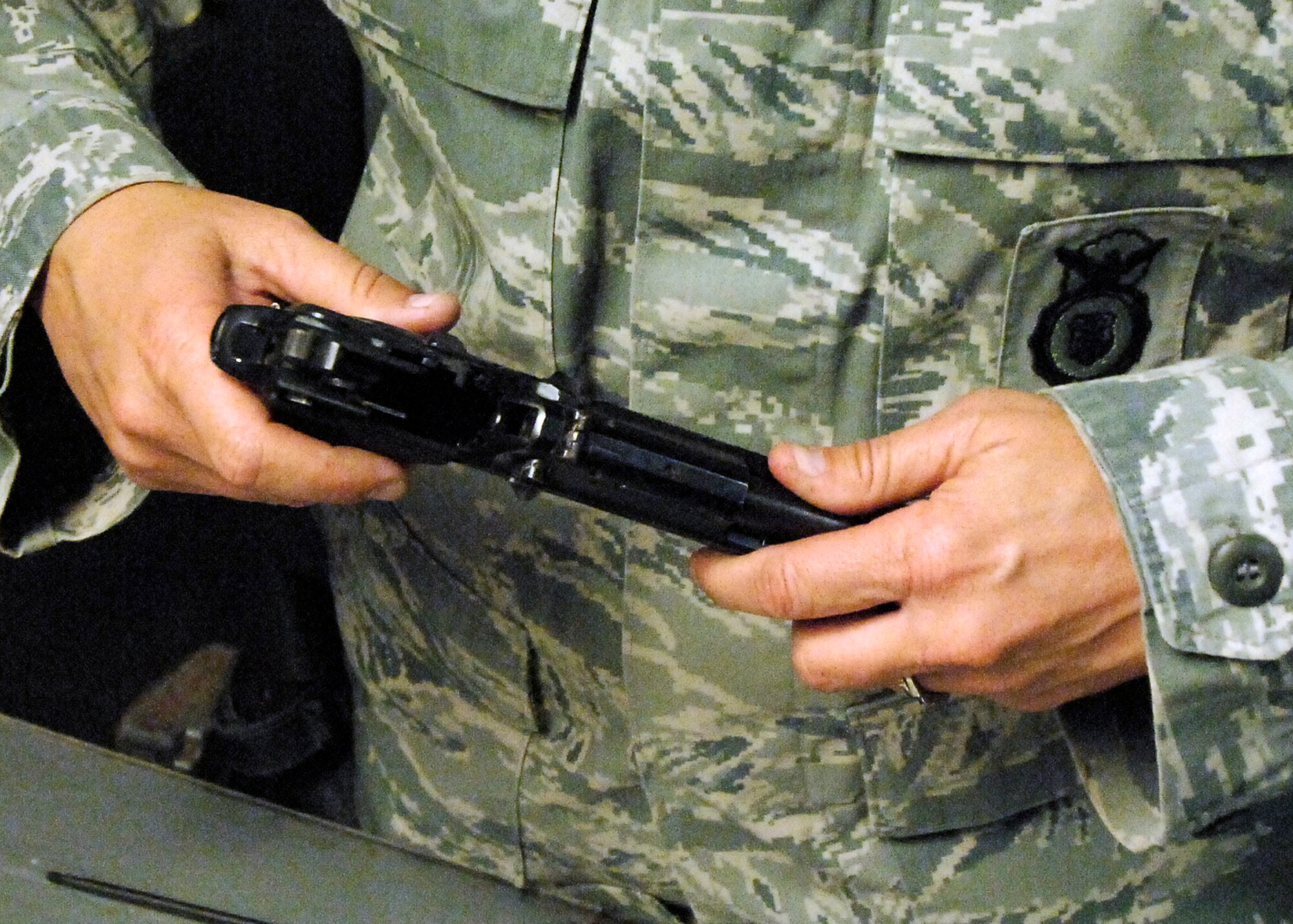 BAGRAM AIRFIELD, Afghanistan -- Tech. Sgt. Kimberley Grann, the noncommissioned officer-in-charge of physical security from the 455th Expeditionary Security Forces Squadron, reassembles her M-9 pistol, Oct. 21, 2009.  Members of Bagram Airfield are advised to clean their weapons routinely.  This assures that member's weapons work properly and safely if needed.  Sergeant Grann is deployed from Pope Air Force Base, N.C., and hails from Madison, Wis.  (U.S. Air Force photo/Senior Airman Felicia Juenke)