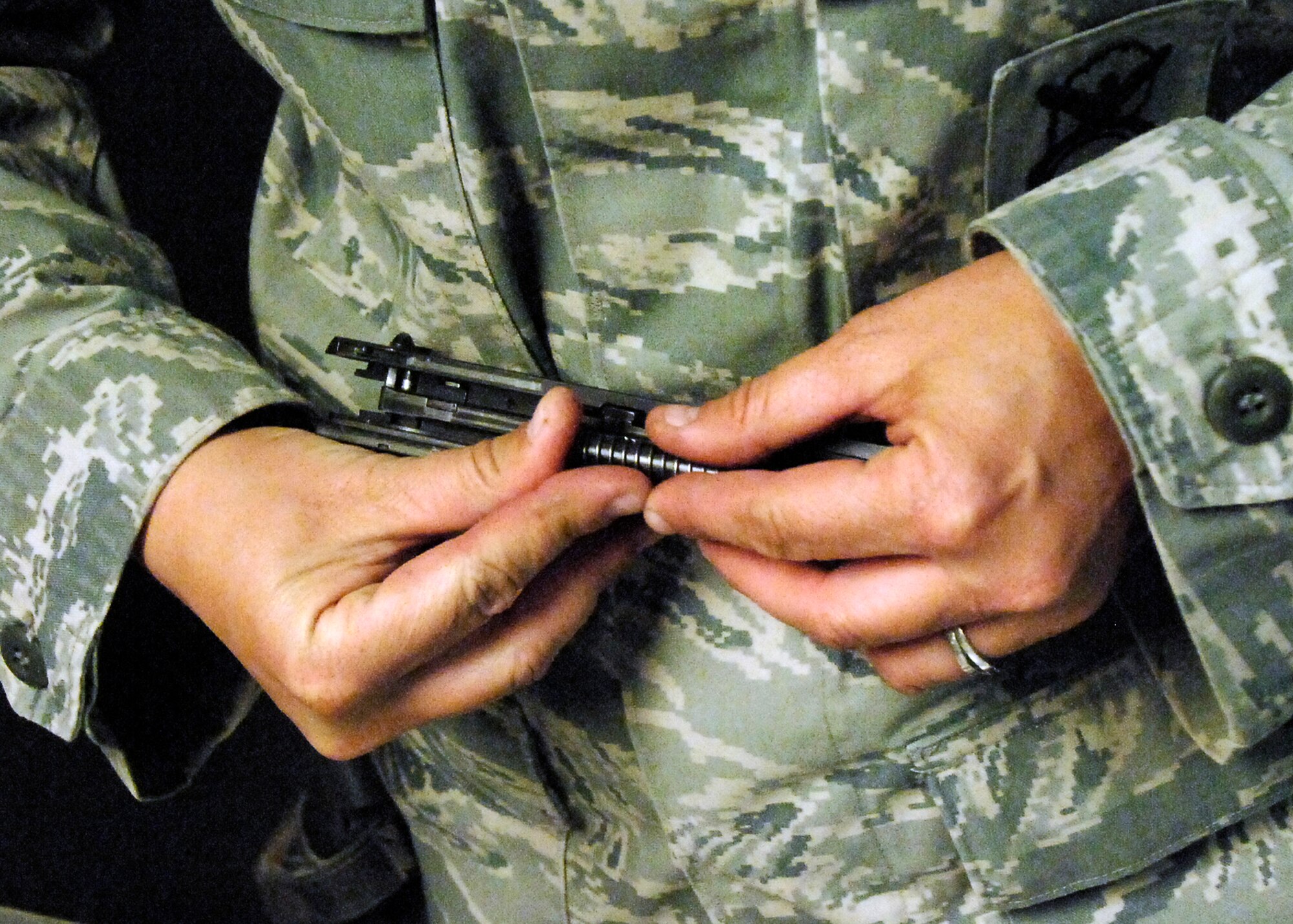 BAGRAM AIRFIELD, Afghanistan -- Tech. Sgt. Kimberley Grann, the noncommissioned officer-in-charge of physical security from the 455th Expeditionary Security Forces Squadron, reassembles her M-9 pistol, Oct. 21, 2009.  Members of Bagram Airfield are advised to clean their weapons routinely.  This assures that member's weapons work properly and safely if needed.  Sergeant Grann is deployed from Pope Air Force Base, N.C., and hails from Madison, Wis.  (U.S. Air Force photo/Senior Airman Felicia Juenke)
