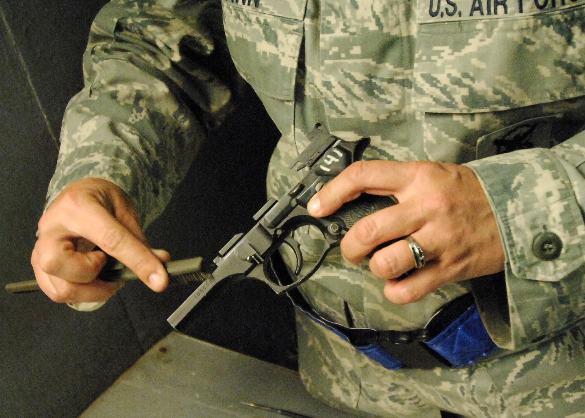 BAGRAM AIRFIELD, Afghanistan -- Tech. Sgt. Kimberley Grann, the noncommissioned officer-in-charge of physical security from the 455th Expeditionary Security Forces Squadron, cleans slide of her M-9 pistol here, Oct. 21, 2009.  Members of Bagram Airfield are advised to clean their weapons routinely.  This assures that member's weapons work properly and safely if needed.  Sergeant Grann is deployed from Pope Air Force Base, N.C., and hails from Madison, Wis.  (U.S. Air Force photo/Senior Airman Felicia Juenke)