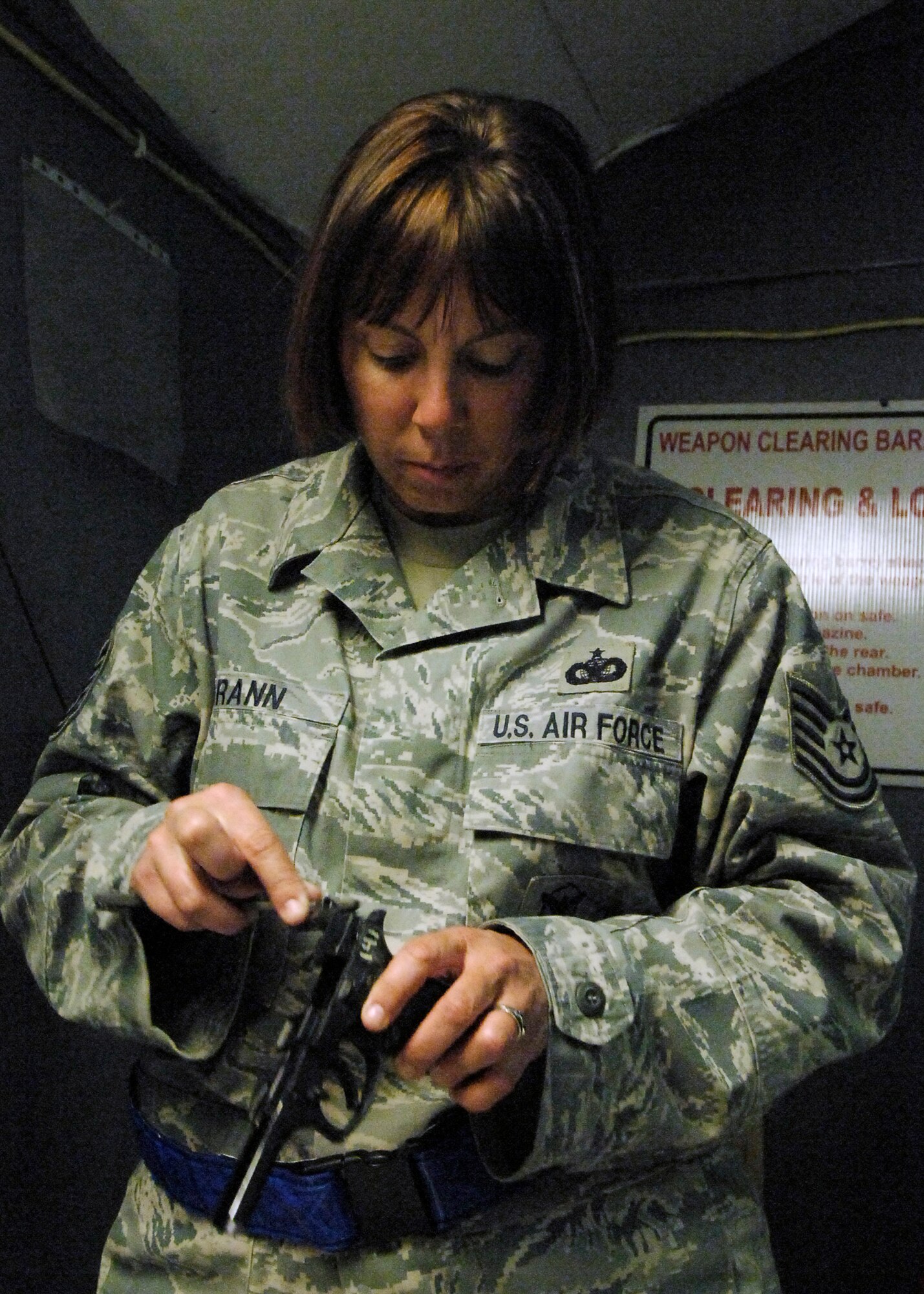 BAGRAM AIRFIELD, Afghanistan -- Tech. Sgt. Kimberley Grann, the noncommissioned officer-in-charge of physical security from the 455th Expeditionary Security Forces Squadron, cleans slide of her M-9 pistol here, Oct. 21, 2009.  Members of Bagram Airfield are advised to clean their weapons routinely.  This assures that member's weapons work properly and safely if needed.  Sergeant Grann is deployed from Pope Air Force Base, N.C., and hails from Madison, Wis.  (U.S. Air Force photo/Senior Airman Felicia Juenke)
