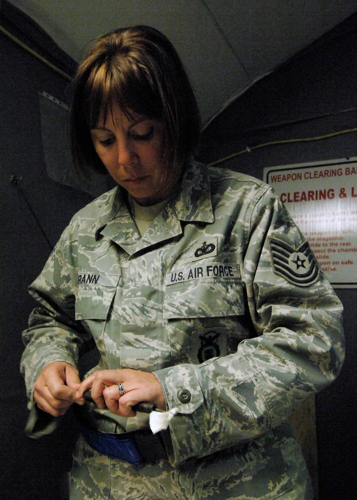 BAGRAM AIRFIELD, Afghanistan -- Tech. Sgt. Kimberley Grann, the noncommissioned officer-in-charge of physical security from the 455th Expeditionary Security Forces Squadron, cleans the barrel of her M-9 pistol here, Oct. 21, 2009.  Members of Bagram Airfield are advised to clean their weapons routinely.  This assures that member's weapons work properly and safely if needed.  Sergeant Grann is deployed from Pope Air Force Base, N.C., and hails from Madison, Wis.  (U.S. Air Force photo/Senior Airman Felicia Juenke)