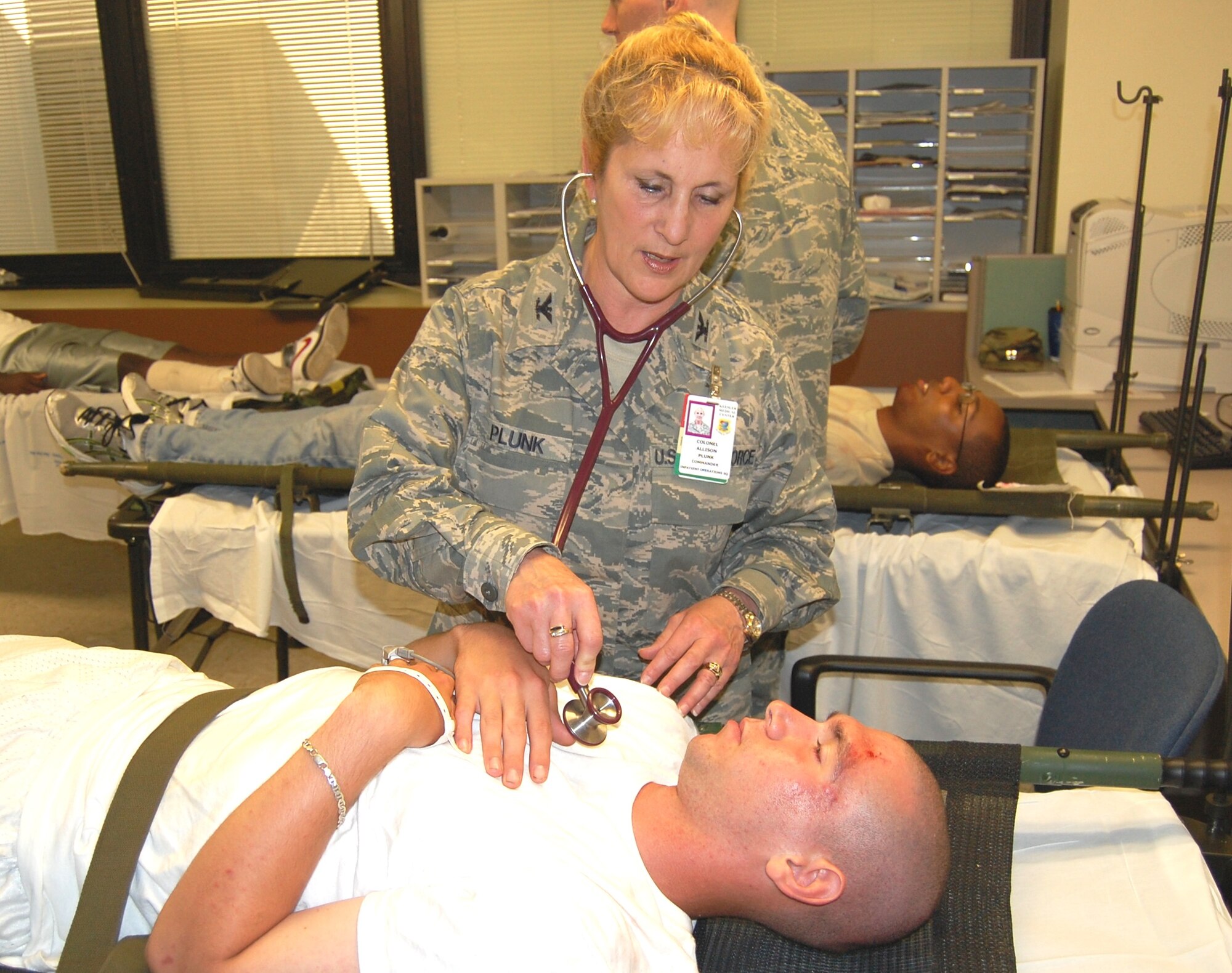 Col. Allison Plunk, 81st Inpatient Operations Squadron commander, checks the vital signs of a bus accident victim brought to the medical inpatient unit during an Oct. 8 mass casualty exercise.  As part of the exercise, the staff had to complete a bed expansion, adding additional beds to a room normally used for administrative purposes.  About 50 students from the 81st Training Group played the roles of casualties for the exercise.  In addition to the “Dragon Medics,” members of the Keesler Fire Department, 81st Security Forces Squadron and 81st Force Support Squadron casualty assistance team participated in the annual mass casualty event.  (U.S. Air Force photo by Steve Pivnick)